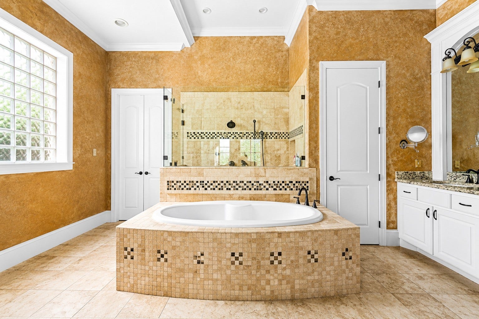 Luxurious primary bath featuring a tiled soaking tub, spacious walk-in shower, elegant finishes, and abundant natural light.