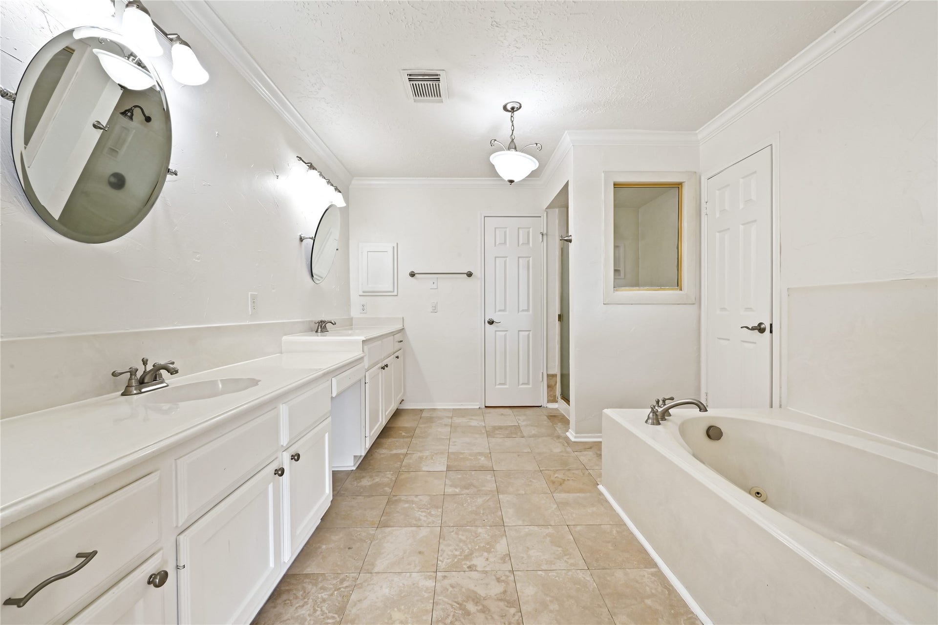 2607 Sailboat Drive, Houston, TX 77058 Ample space bathroom featuring dual sinks, elegant fixtures, a luxurious soaking tub, and a separate shower, all set against tasteful tile flooring.