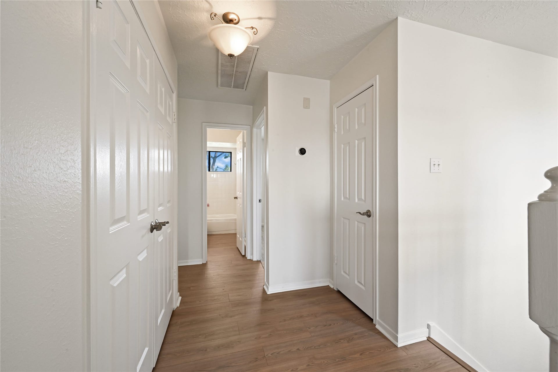 2607 Sailboat Drive, Houston, TX 77058 Bright and welcoming hallway with sleek hardwood floors, modern light fixture, and multiple doorways leading to spacious rooms.
