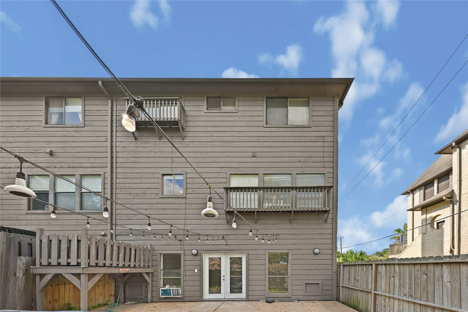 2607 Sailboat Drive, Houston, TX 77058 Open backyard with a wooden deck and charming string lights, perfect for entertaining or relaxing.
