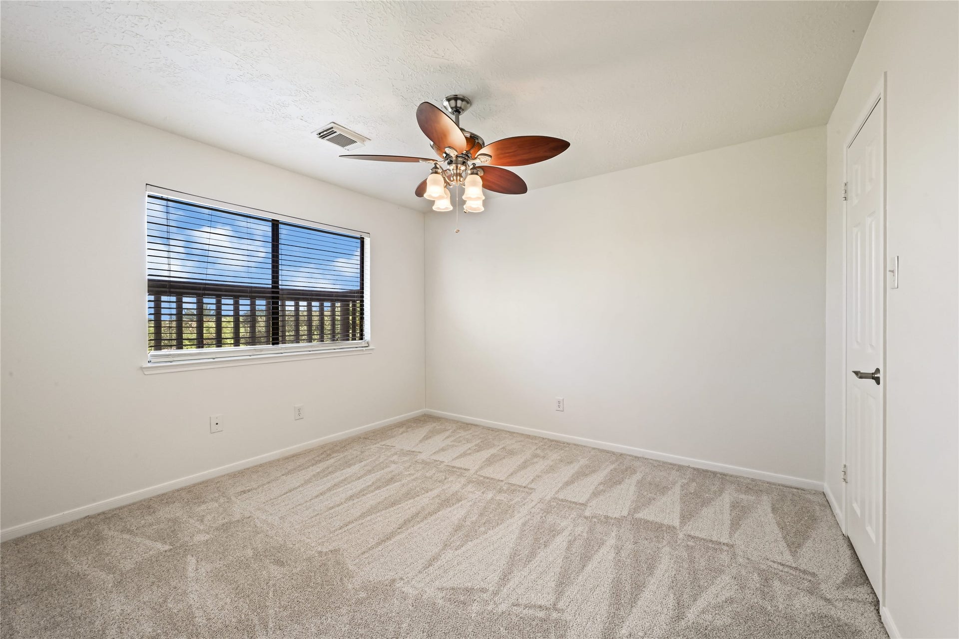 2607 Sailboat Drive, Houston, TX 77058 Bright and airy bedroom featuring plush carpet, a modern ceiling fan with lights, and a large window offering plenty of natural light.