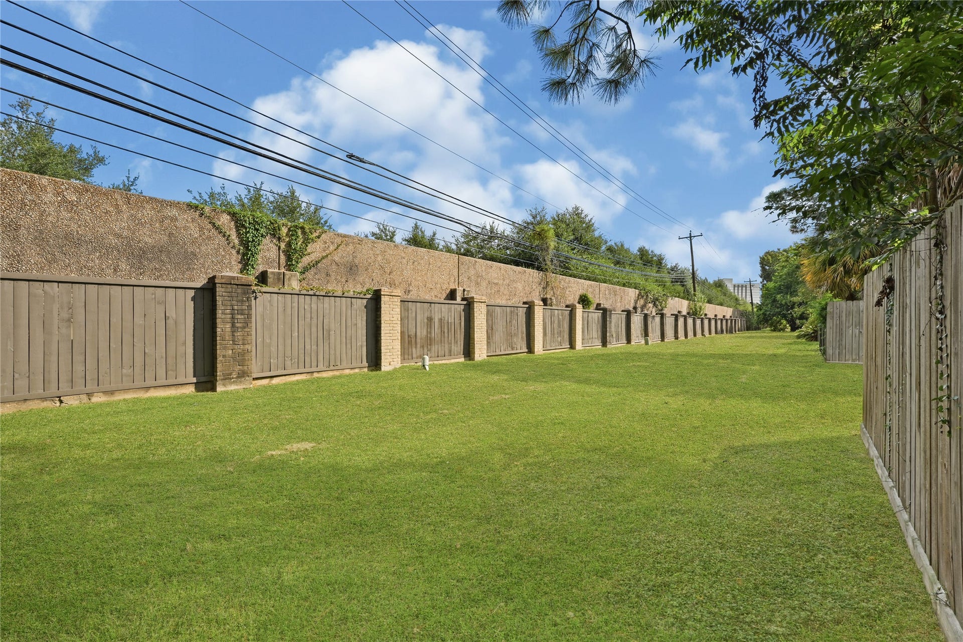 2607 Sailboat Drive, Houston, TX 77058 Well-maintained lawn area bordered by a sturdy wooden fence, offering privacy and a sense of openness.