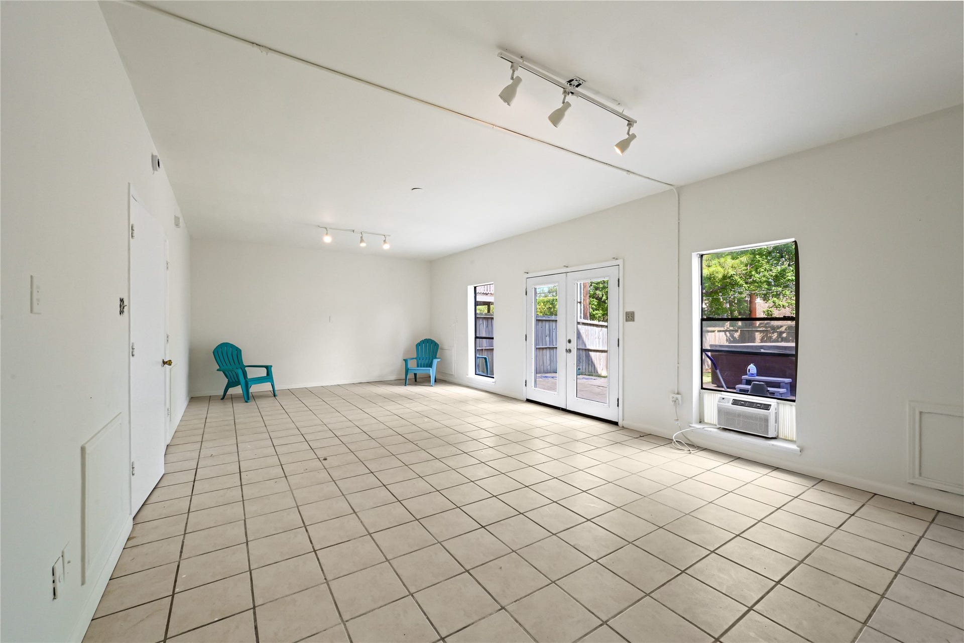 2607 Sailboat Drive, Houston, TX 77058 Spacious and bright living area with tile flooring, featuring large windows and a door leading to the outdoor space, perfect for gatherings.
