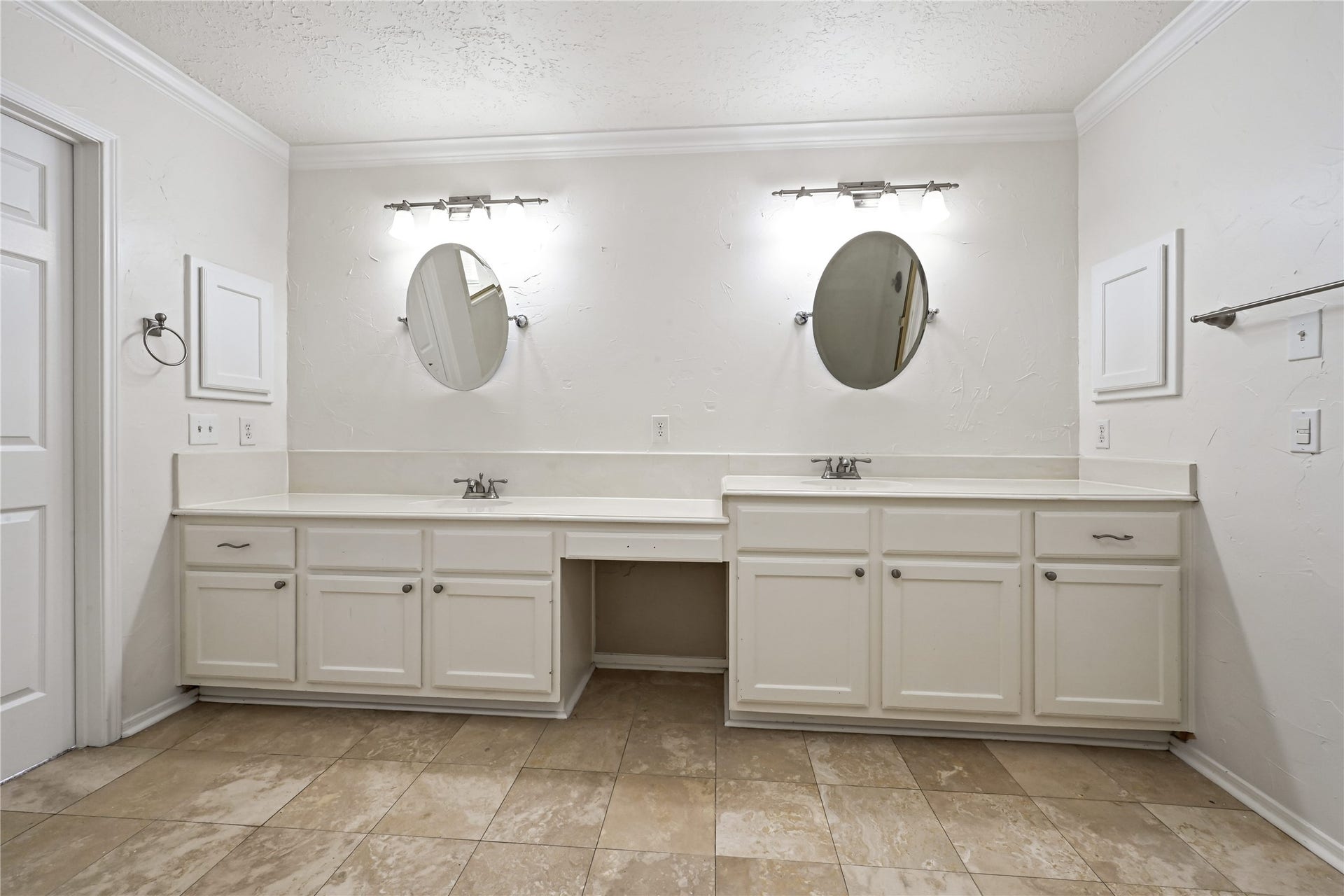 2607 Sailboat Drive, Houston, TX 77058 Spacious bathroom with dual sinks, elegant oval mirrors, and ample cabinetry, all complemented by stylish tile flooring.