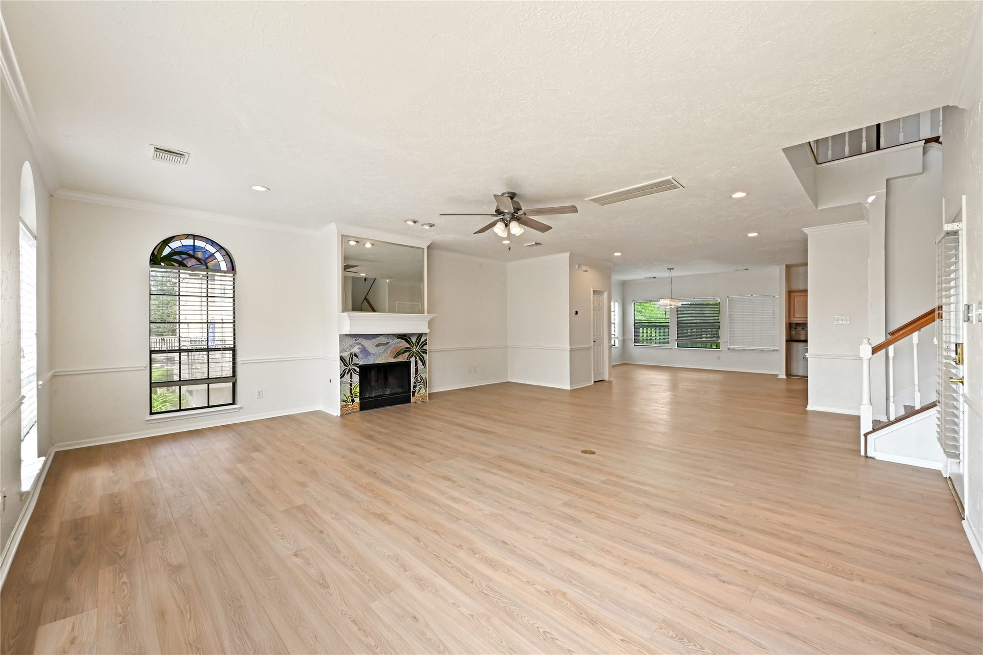 2607 Sailboat Drive, Houston, TX 77058 Open-concept living area with elegant wood flooring, a cozy fireplace, and abundant natural light from large windows.