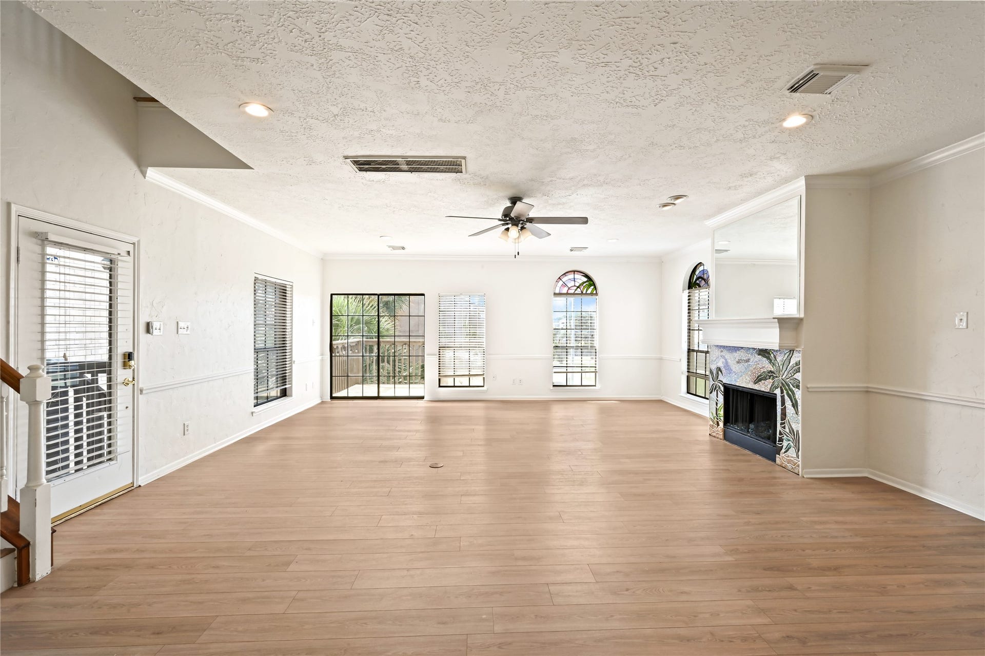2607 Sailboat Drive, Houston, TX 77058 Spacious living area with abundant natural light, featuring elegant wood flooring, a decorative fireplace, and large windows offering scenic views.