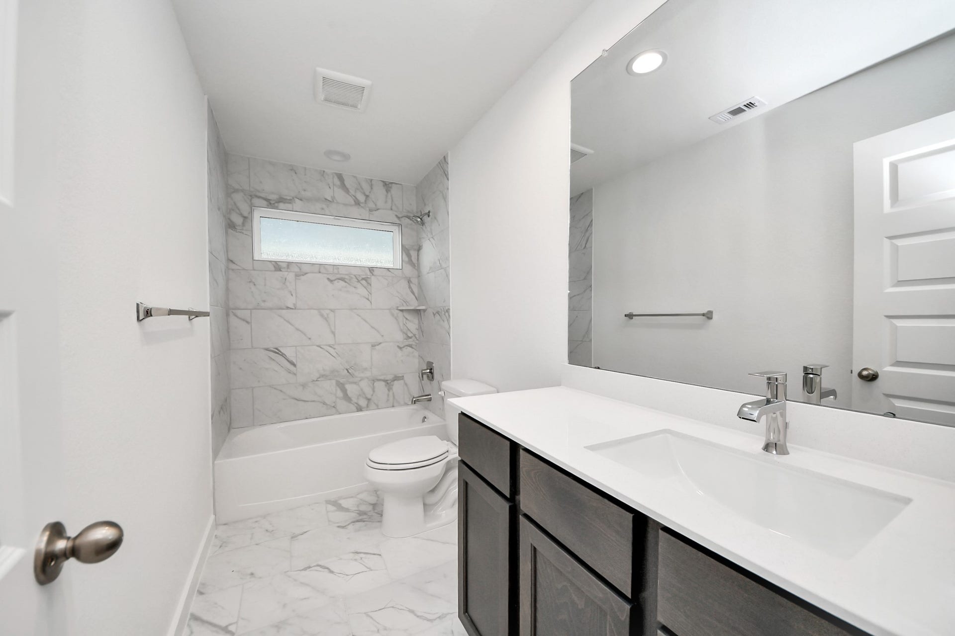 24515 Broad Park Ct, Spring, TX 77373 Secondary bath features tile flooring, bath/shower combo with tile surround, light stained wood cabinets, beautiful light countertop.