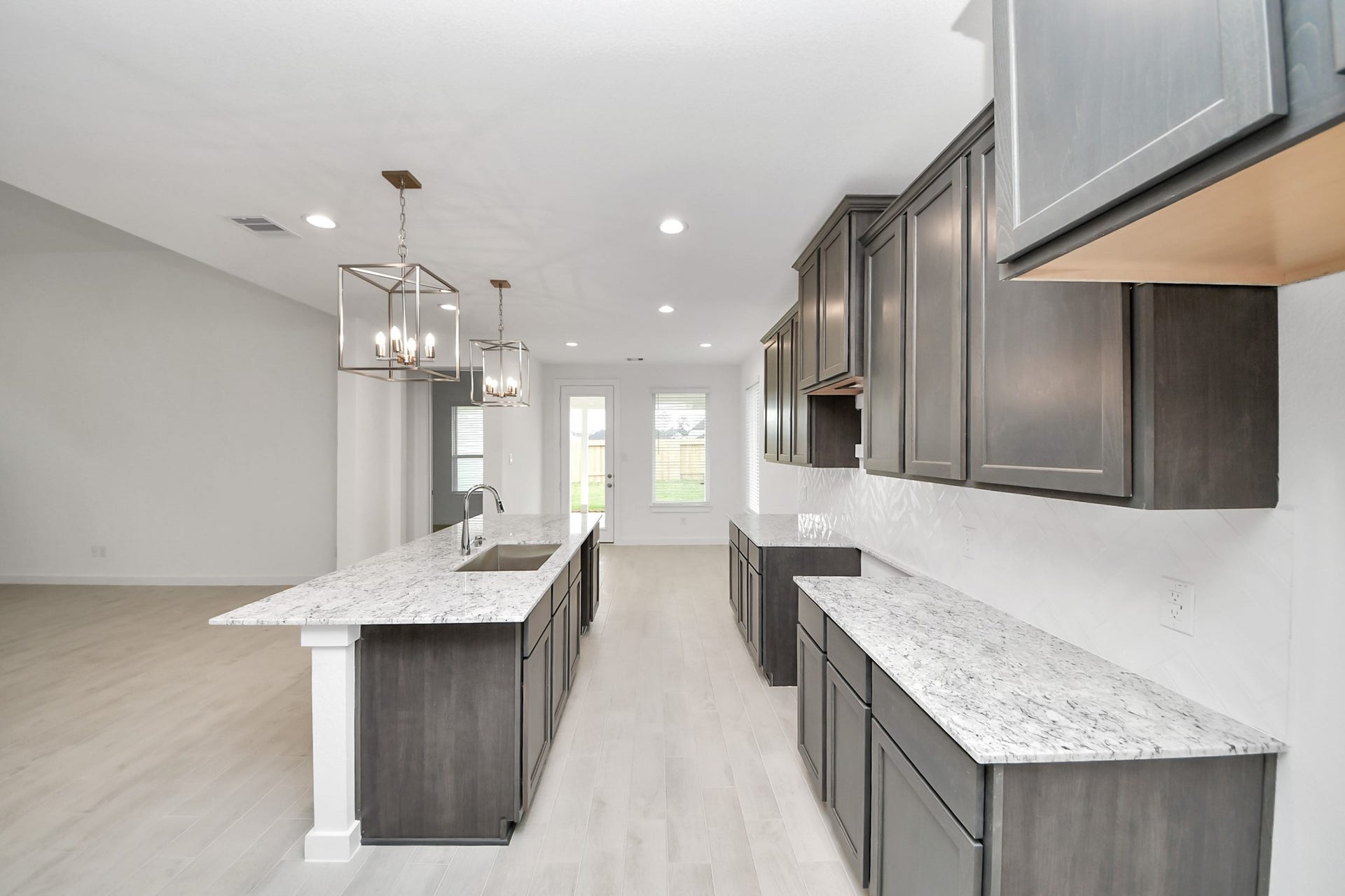 24515 Broad Park Ct, Spring, TX 77373 Step into a dream realized with this generously spacious kitchen! A massive granite island takes center stage, complemented by high ceilings and soft-close cabinets. The granite countertops, stainless steel appliances, sleek tile backsplash, and recessed lighting complete the elegant design.