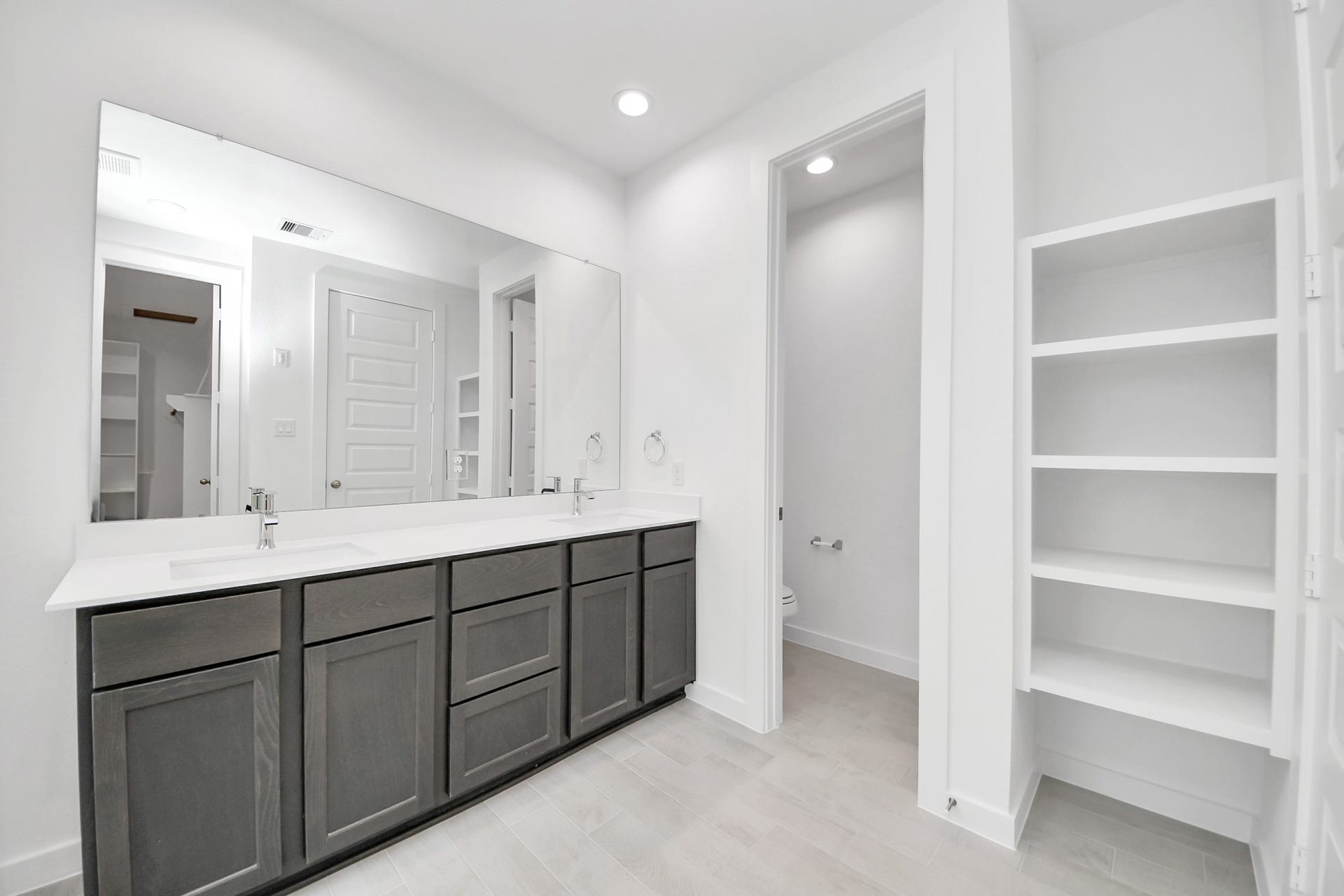 24515 Broad Park Ct, Spring, TX 77373 Elevate your daily routine at the elegant vanity, now equipped with double sinks, light countertops, modern hardware, and beautiful recessed lights.