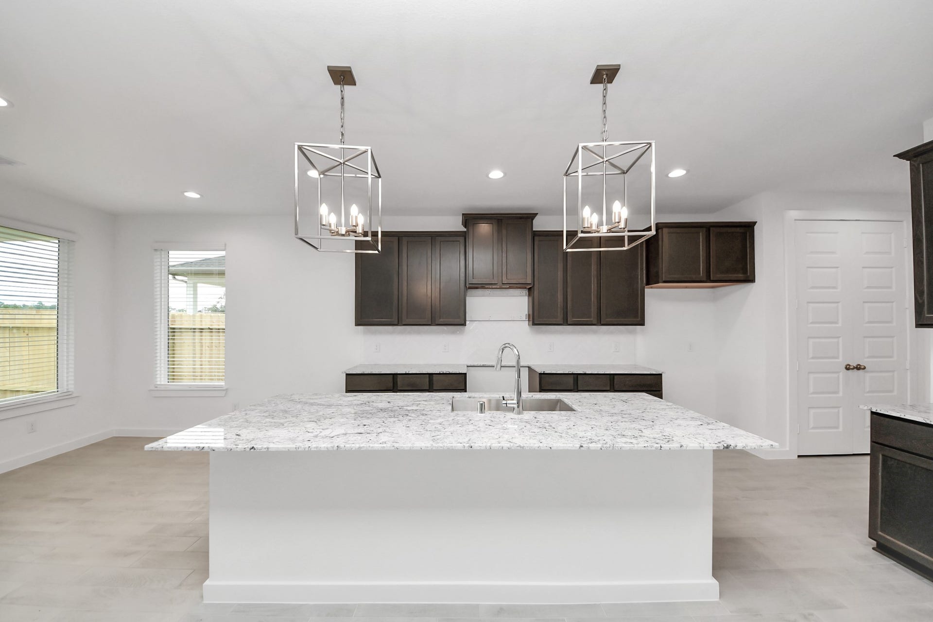 24515 Broad Park Ct, Spring, TX 77373 This kitchen is truly a chef's dream! This haven Boasts high ceilings, recessed & pendant lighting, stained wood cabinets, granite countertops, stainless steel appliances, a modern tile backsplash. All of this overlooks your expansive family room, creating a perfect space for culinary delights and family gatherings.