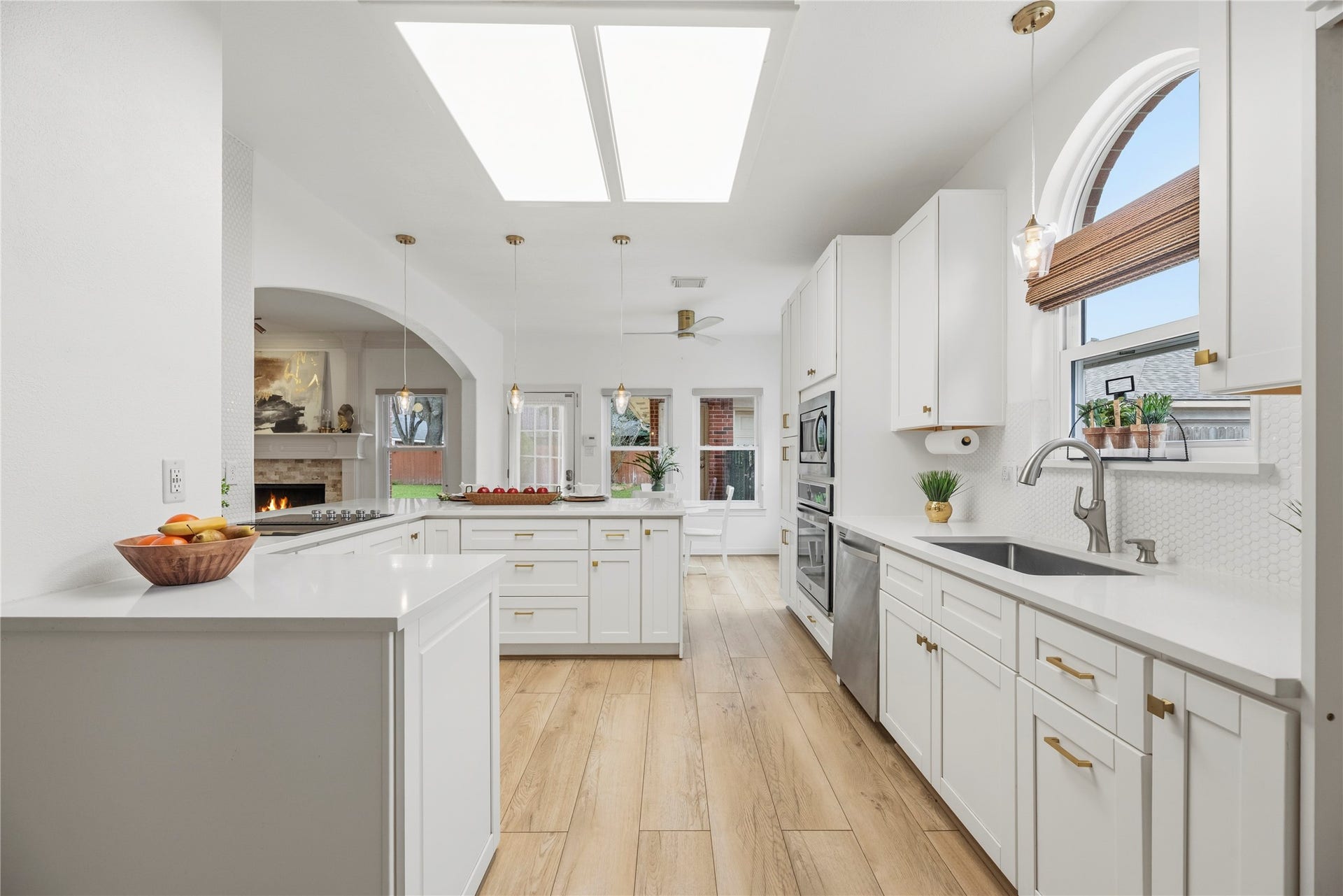 Gourmet kitchen features quartz countertops, tile backsplash, white cabinetry with soft close drawers and pull out shelving, and stainless steel appliances.
