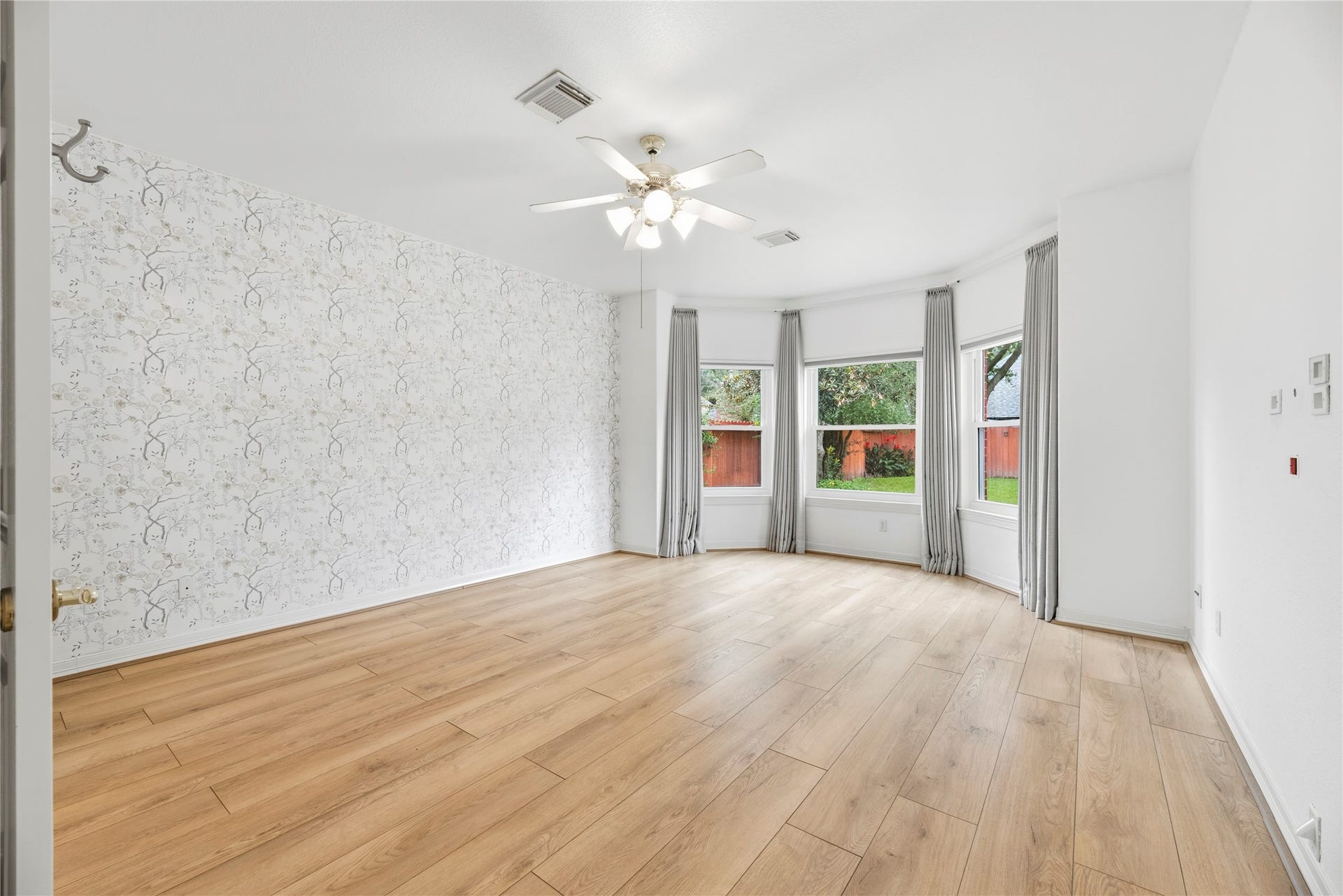 Primary bedroom with a designer accent wall, sitting area and en-suite bathroom.