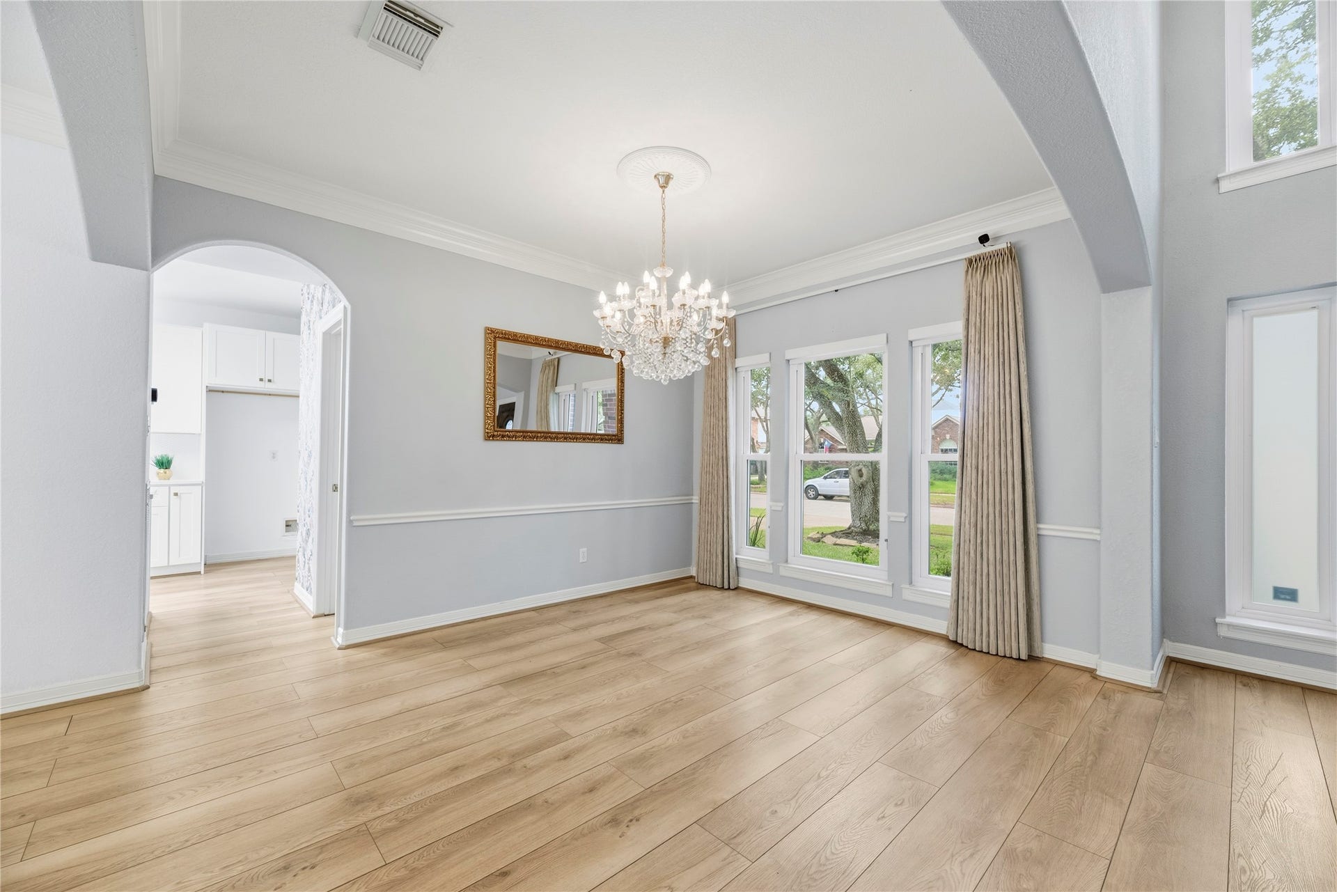 Formal dining room just off the foyer offers double crown molding and gorgeous second chandelier.