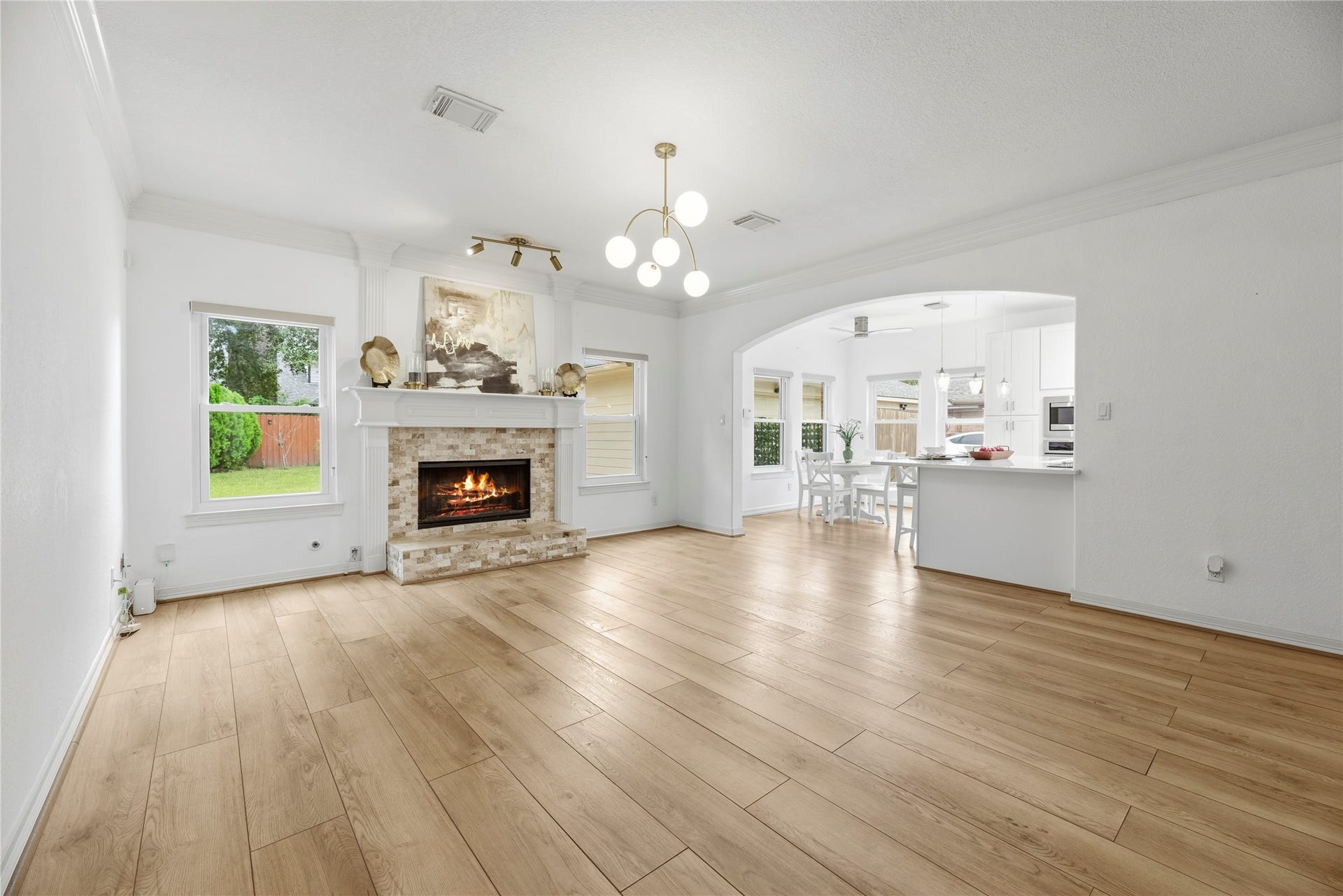 The family room boasts double crown molding, modern light fixture and cozy gas log fireplace.