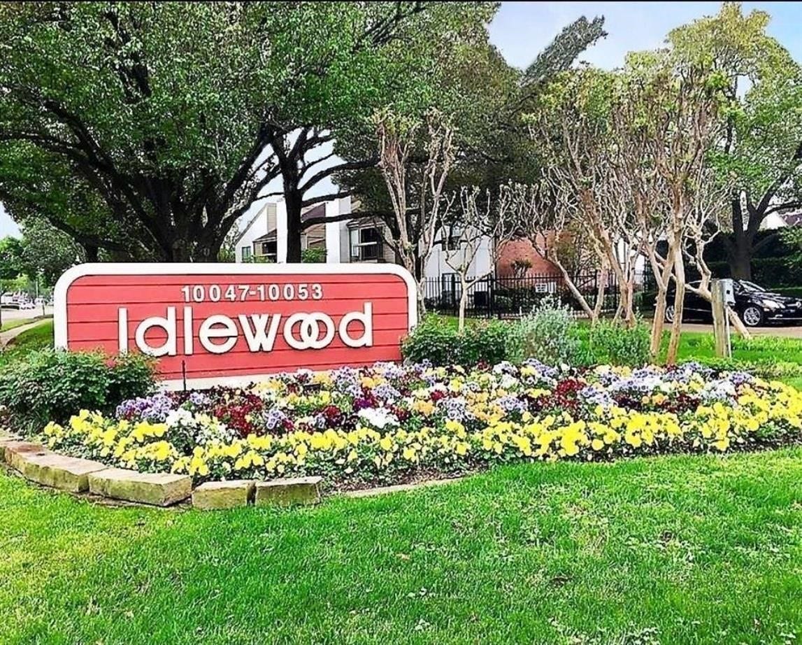 10049 Westpark Drive, #136, Houston, TX 77042 Charming entrance to a residential community, featuring a vibrant flower bed and a welcoming "Idlewood" sign framed by lush trees. Ideal for buyers seeking a picturesque neighborhood.