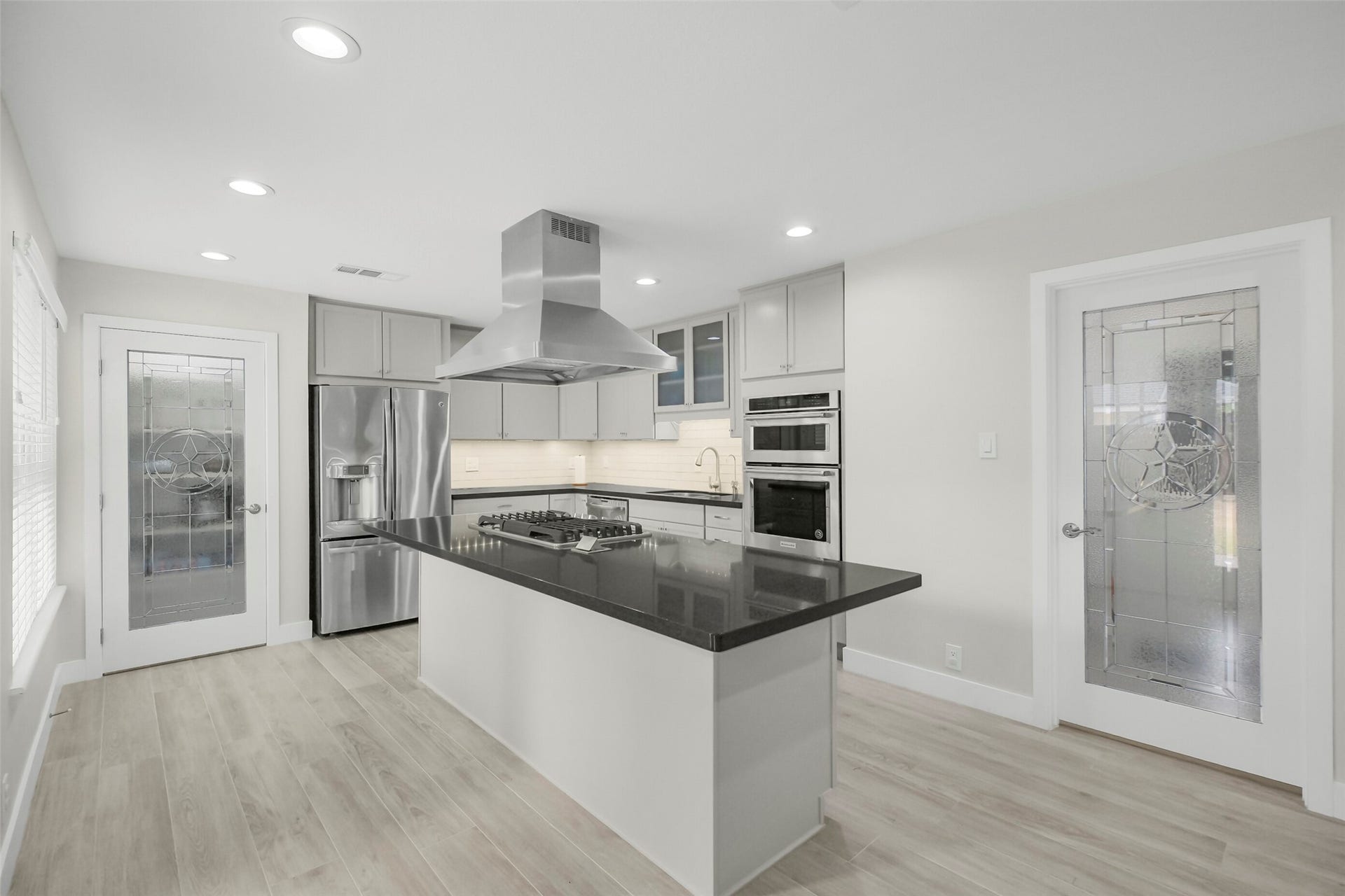 1710 Willowby Drive, Houston, TX 77008 Oversized kitchen makes a great space for entertaining guests. Spacious island with gas cooktop, SS appliances, undercabinet lighting and granite countertops. Left door opens to a spacious pantry while the right door opens to the mudroom and garage.