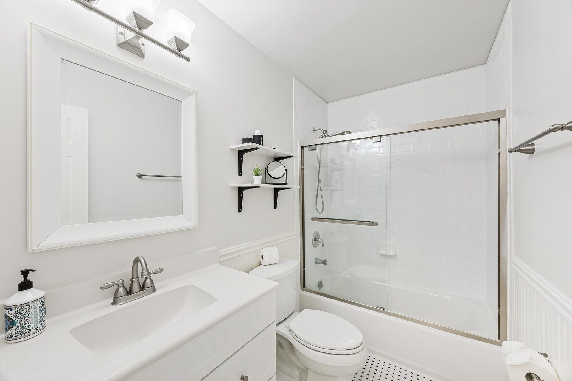 1814 Tiki Drive, Tiki Island, TX 77554 This bright and contemporary bathroom features sleek fixtures, a spacious vanity, and a modern glass-enclosed shower, offering a refreshing retreat in your new home.