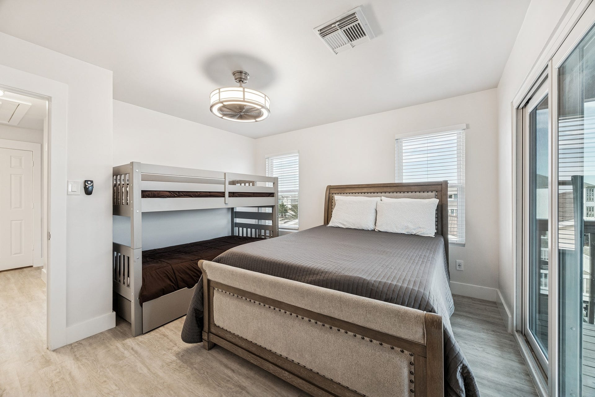1814 Tiki Drive, Tiki Island, TX 77554 This bright and inviting bedroom offers ample space with a cozy bed and stylish bunk beds, perfect for relaxation and family comfort.