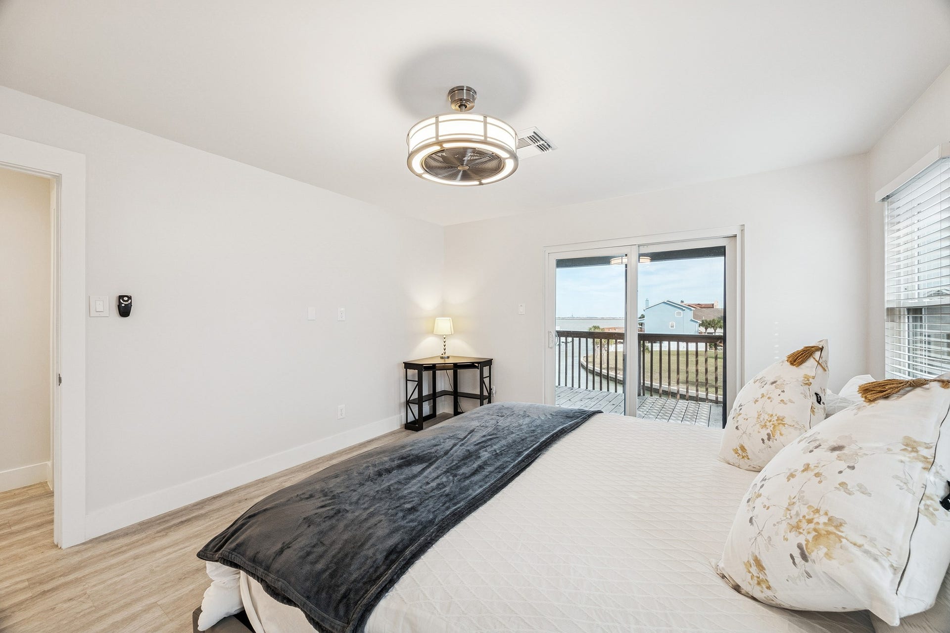 1814 Tiki Drive, Tiki Island, TX 77554 Discover tranquility in this spacious primary bedroom, featuring elegant hardwood floors, abundant natural light, and direct access to a serene balcony with picturesque views.