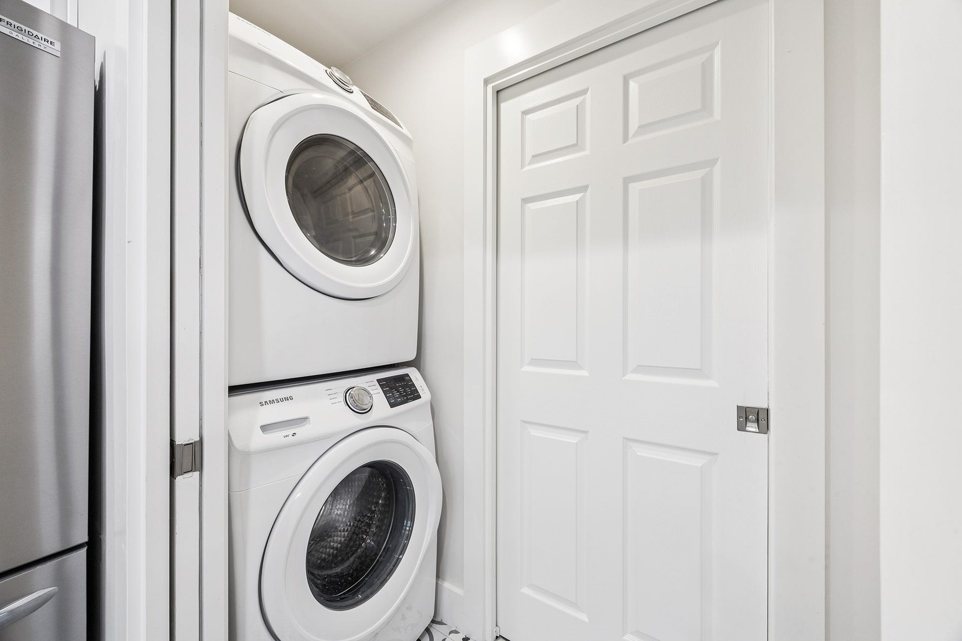 1814 Tiki Drive, Tiki Island, TX 77554 This washroom boasts a sleek, space-saving design with modern stacked laundry appliances, perfect for efficient living.