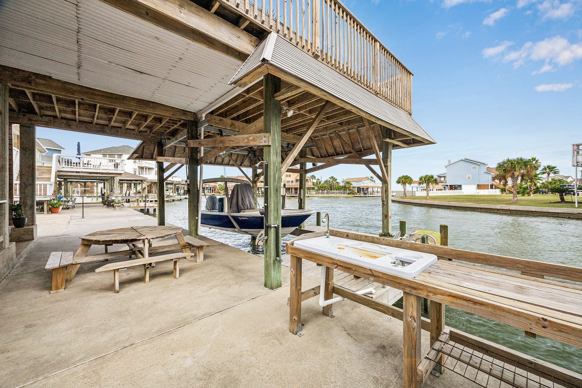 1814 Tiki Drive, Tiki Island, TX 77554 Experience waterfront living with this charming boat house and convenient fish cleaning station, perfect for the avid angler and outdoor enthusiast.