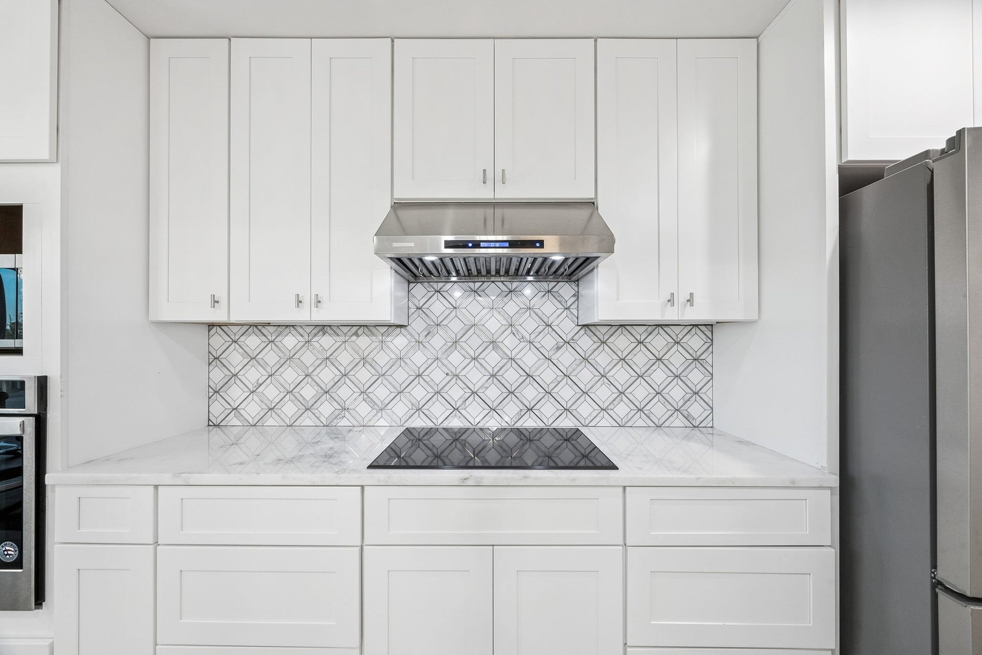 1814 Tiki Drive, Tiki Island, TX 77554 Discover culinary elegance with this sleek kitchen cooktop, set against a stylish backsplash and surrounded by ample storage, perfect for inspiring your inner chef.