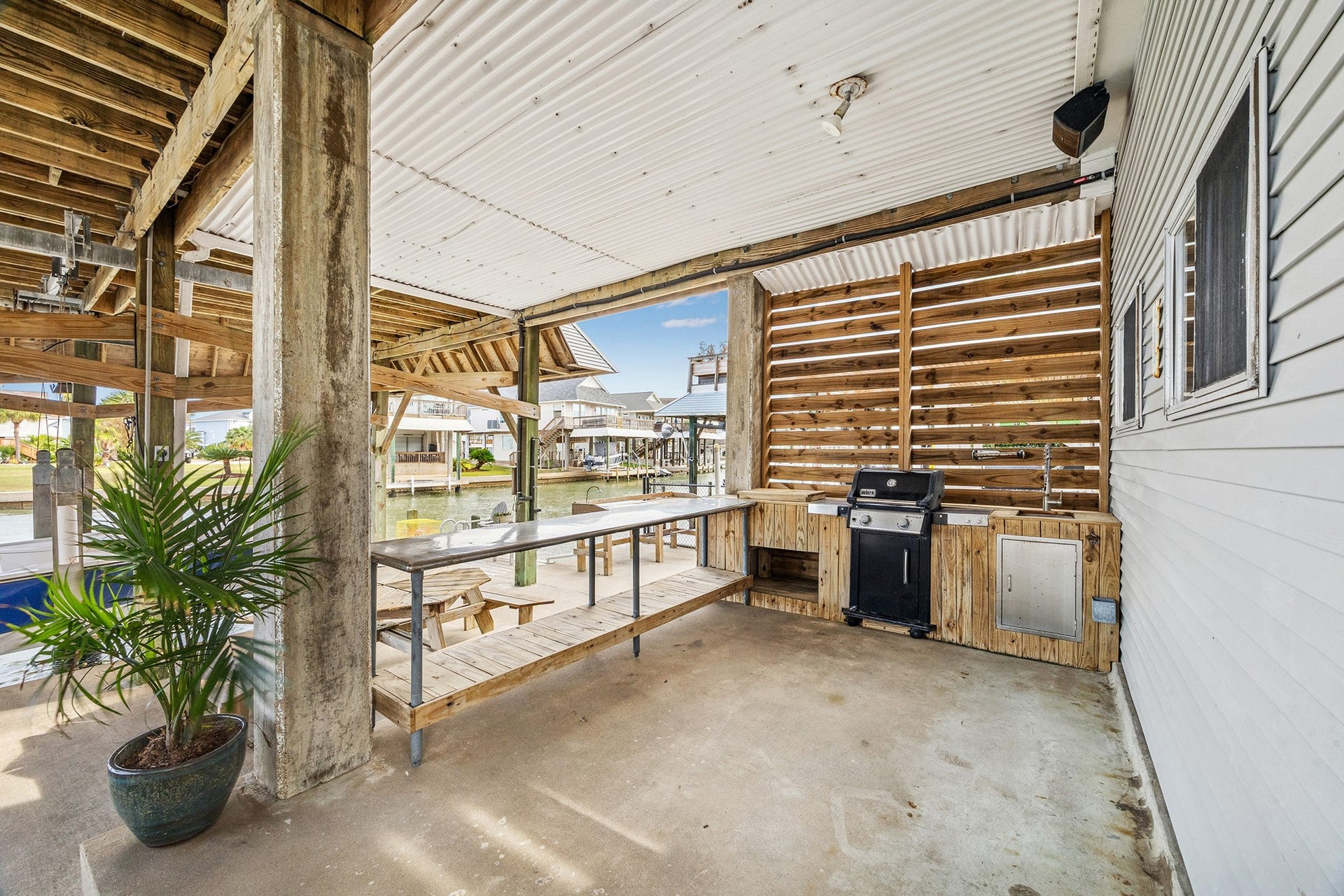 1814 Tiki Drive, Tiki Island, TX 77554 Discover the perfect outdoor oasis with a sleek grill and sink setup, ideal for entertaining while enjoying serene waterfront views.