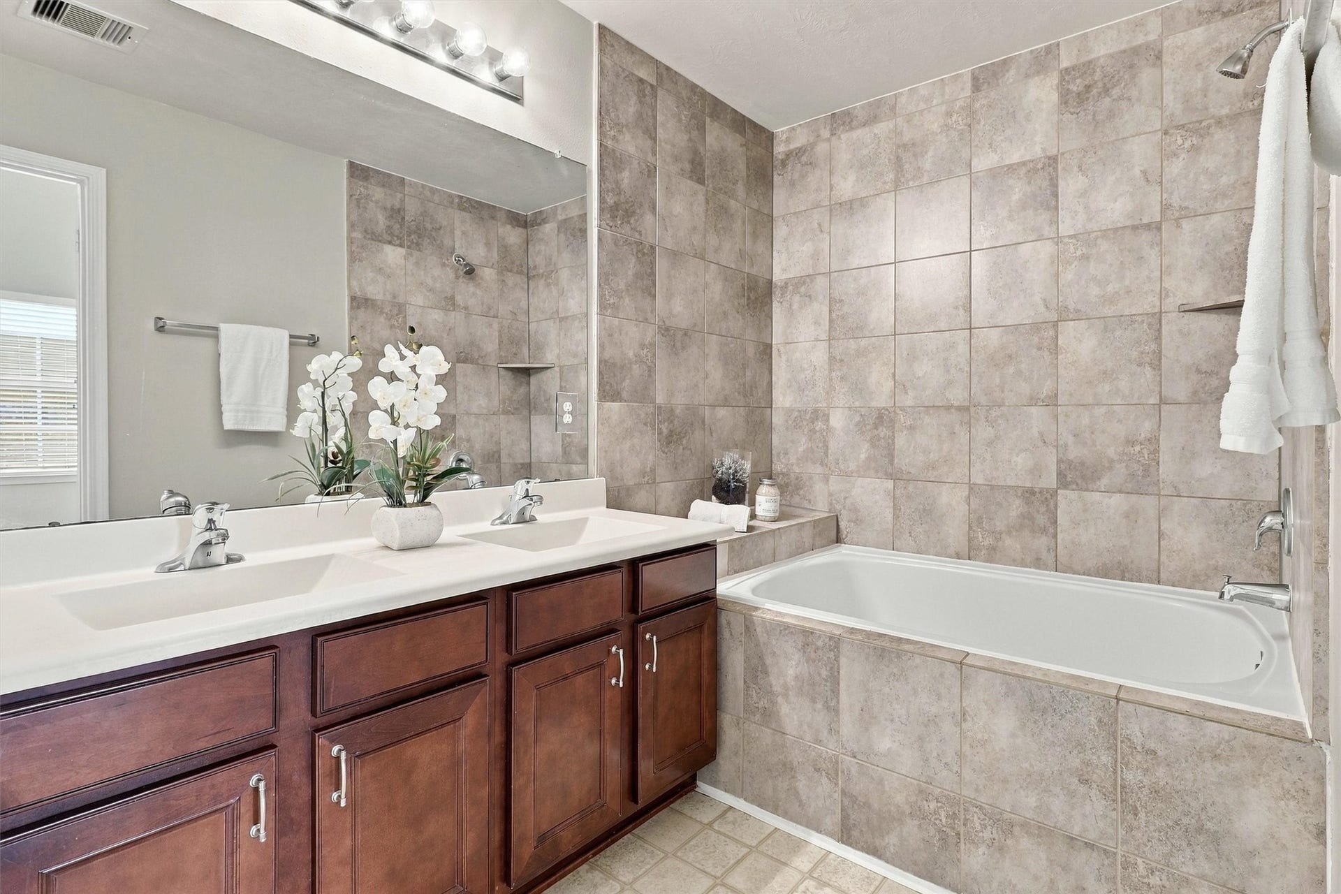 8323 Lamond Lane, Houston, TX 77095 Step through the double doors to find your primary bathroom! This space features a dual vanity with plenty of storage. Two sinks will make getting ready in the morning a breeze. the tub/shower combo features a deep garden tub and elevated tile-surround.