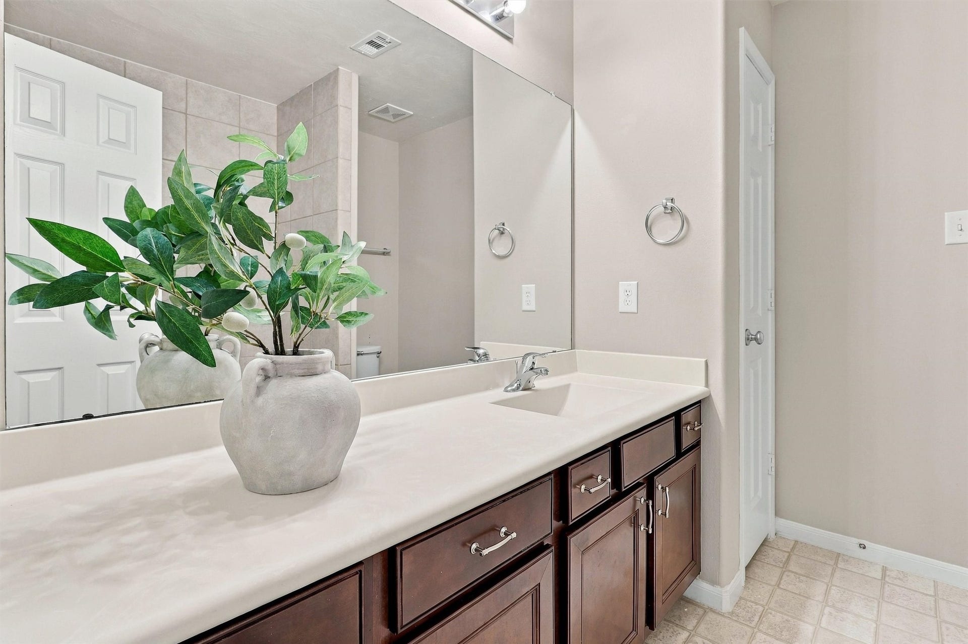 8323 Lamond Lane, Houston, TX 77095 The secondary bath features a long vanity with a single sink. An elegant composite counter beautifully contrasts the rich stain on the cabinetry. Note even more storage is available in the linen closet. The commode is tucked behind the shower wall for privacy.
