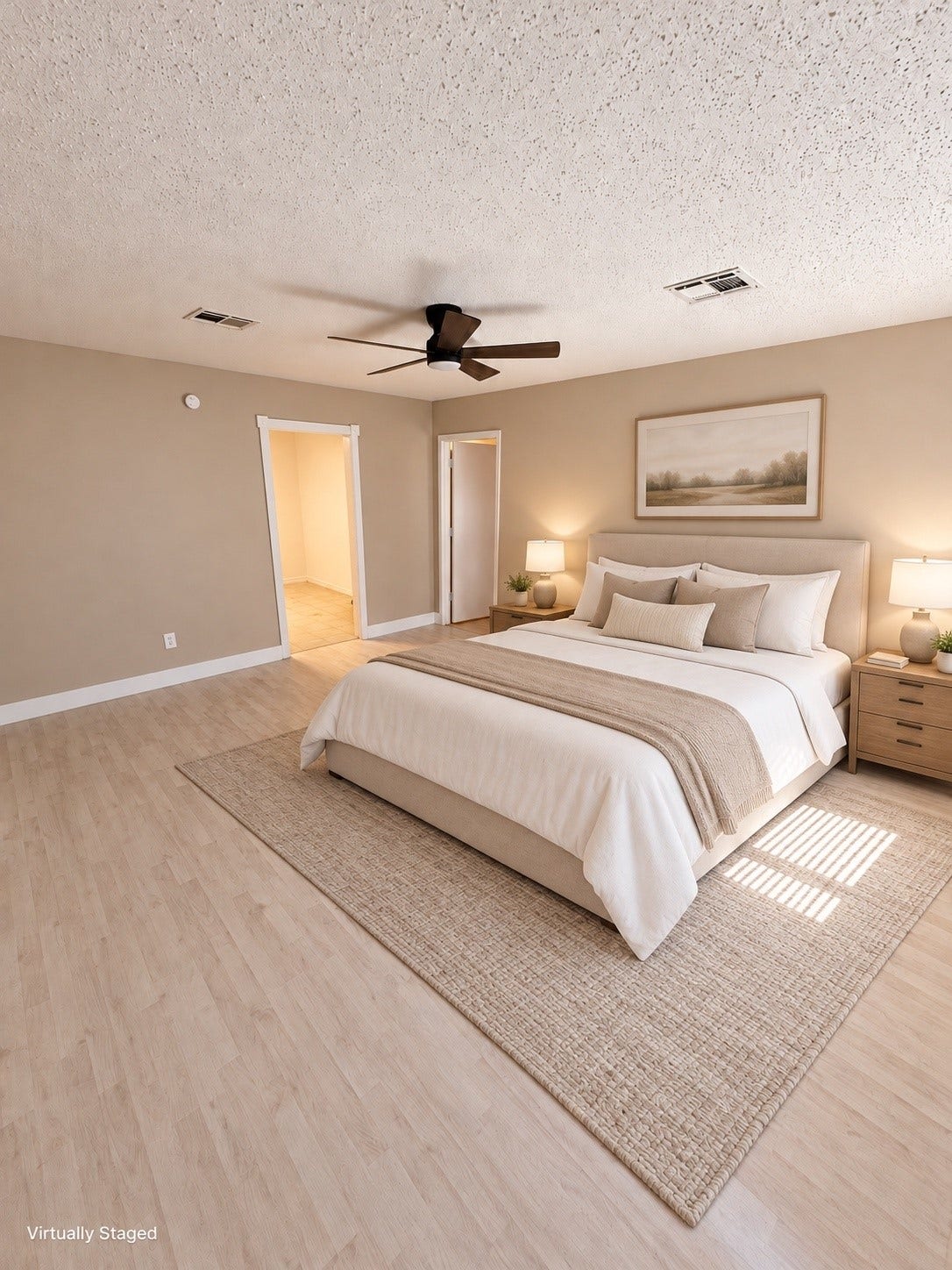 Spacious bedroom with soft, neutral tones, featuring a cozy bed, modern ceiling fan, and ample natural light.