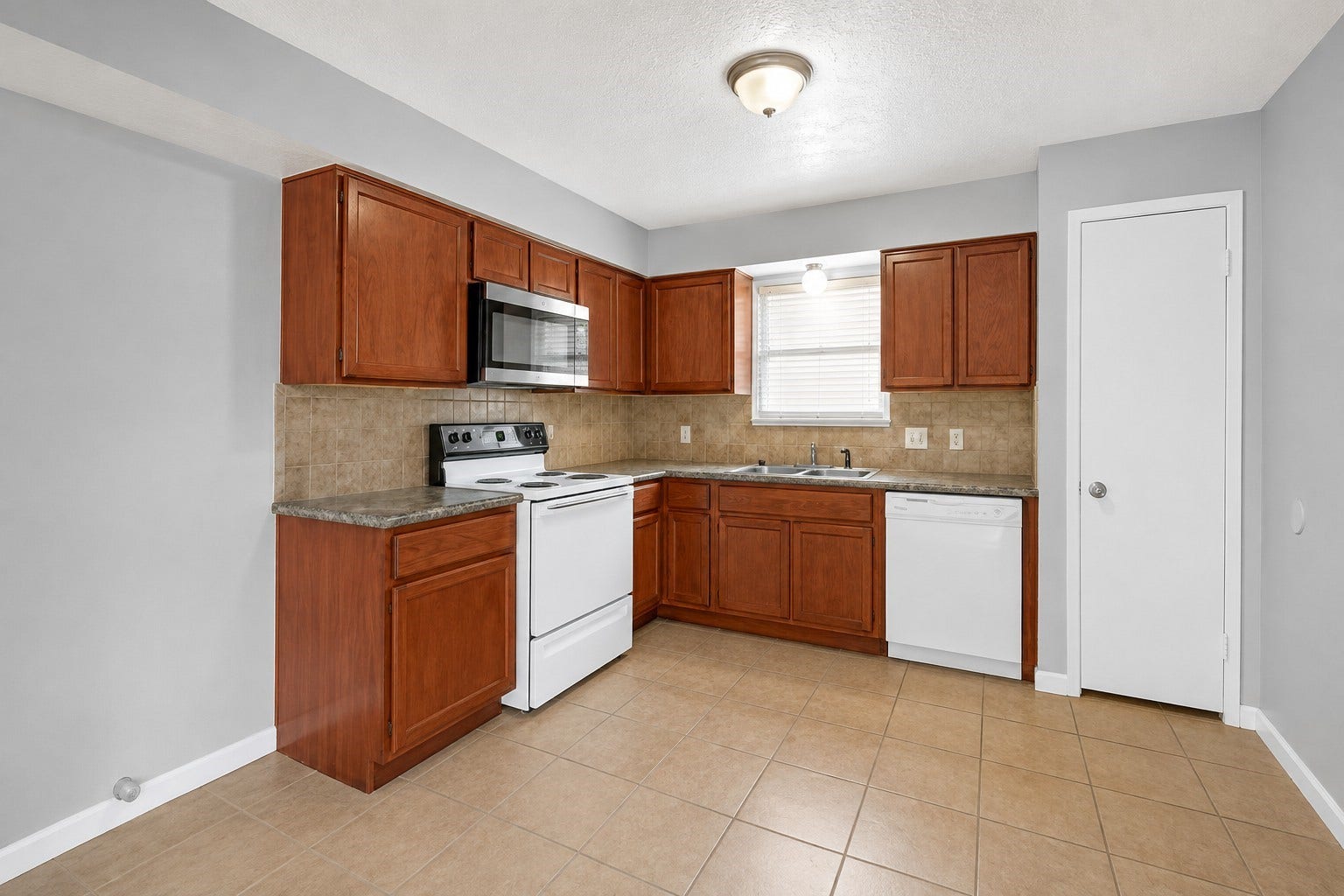 1707 Stone Lake Drive, Missouri City, TX 77489 Functional kitchen featuring generous cabinet and counter space, with a window over the sink providing natural light.