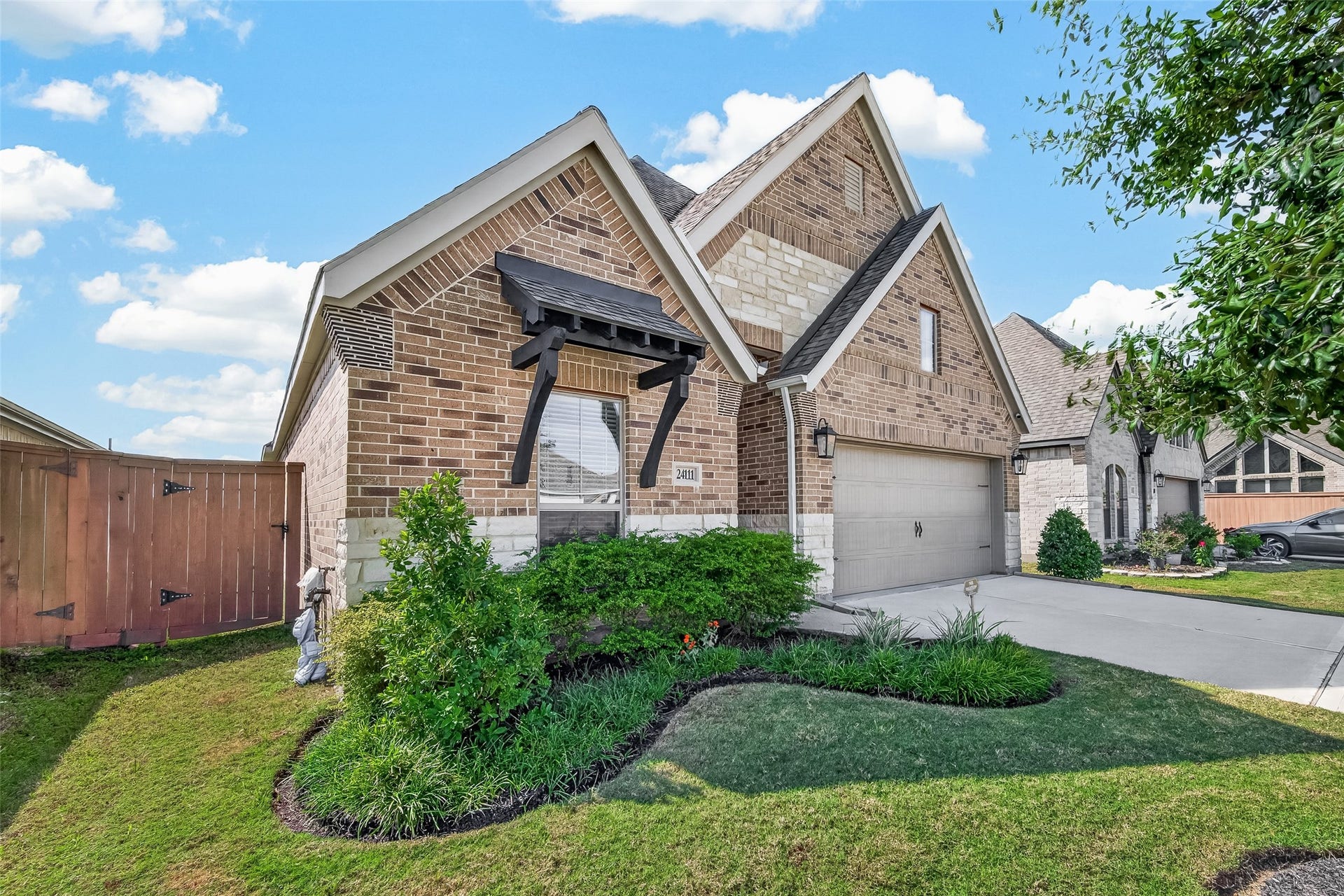 24111 Avocet Creek Road, Katy, TX 77493 This PERRY HOME has beautiful curb appeal including classic brick and stone elevation, manicured landscape, and a green front lawn with maturing trees.