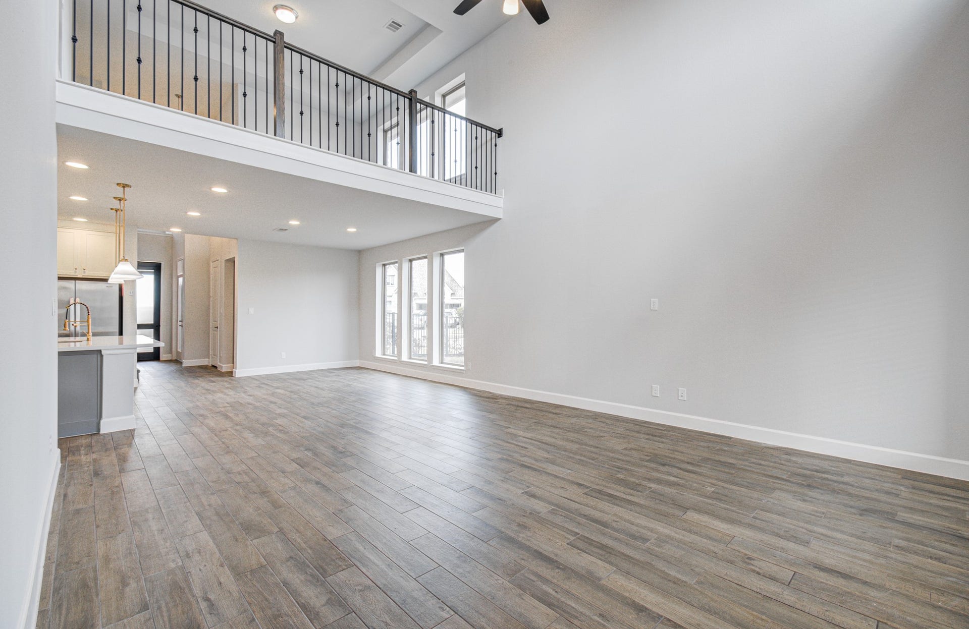 Spacious open-concept living area with high ceilings, elegant flooring, and abundant natural light. The modern kitchen features sleek finishes and pendant lighting, perfect for entertaining.