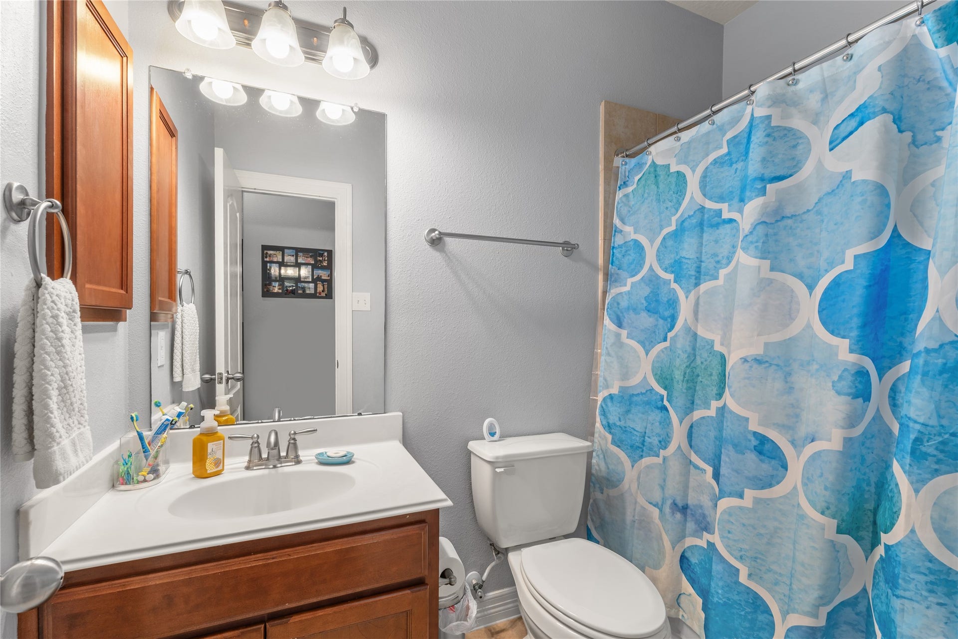 20184 Bitter Root Drive, Porter, TX 77365 Bright and welcoming bathroom with modern fixtures, featuring a stylish shower curtain, a sleek vanity with ample storage, and elegant lighting.