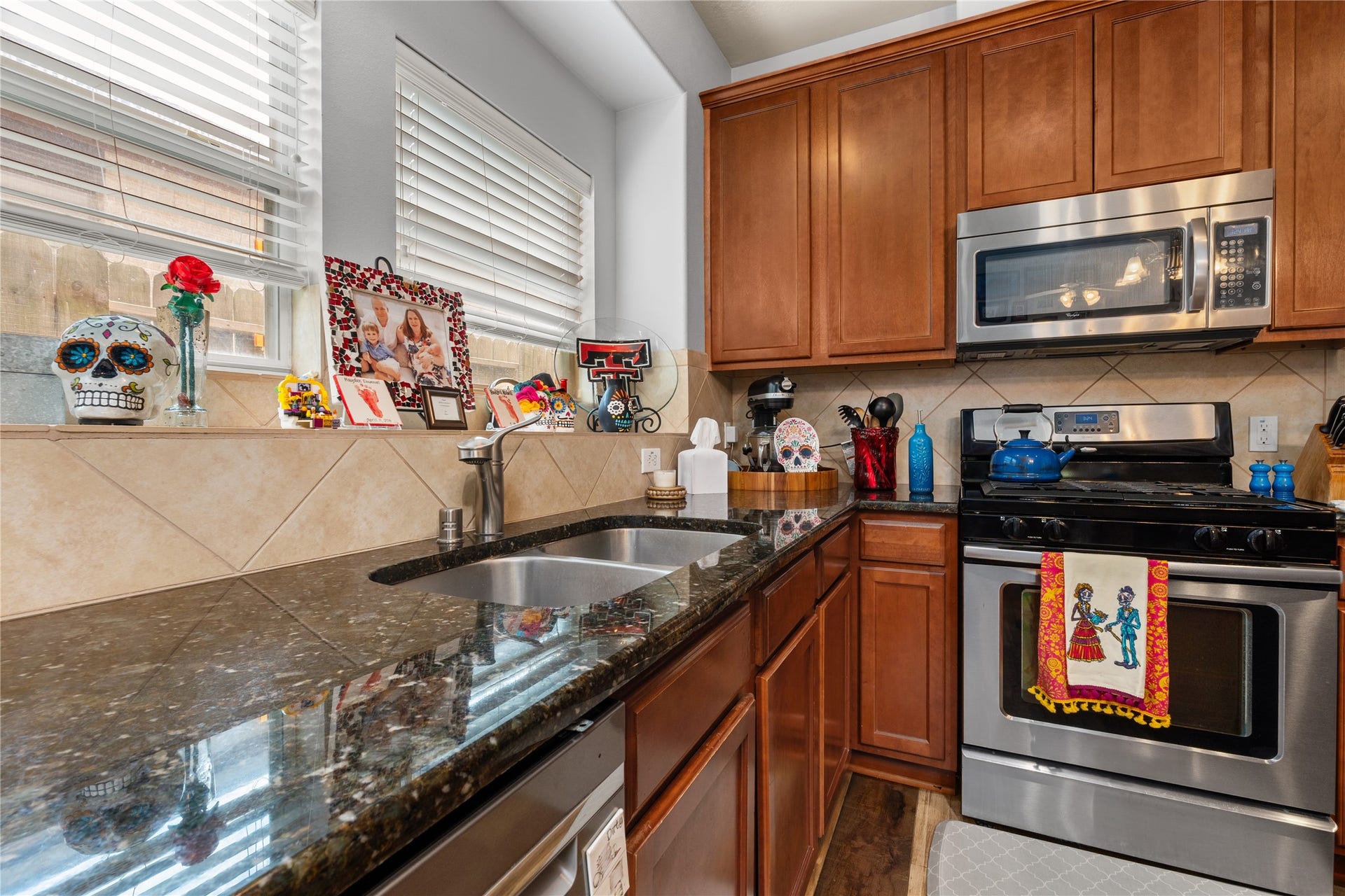 20184 Bitter Root Drive, Porter, TX 77365 Charming kitchen with rich wooden cabinetry, sleek granite countertops, and stainless steel appliances.