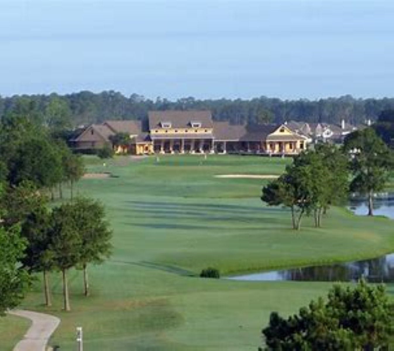 20184 Bitter Root Drive, Porter, TX 77365 Expansive golf course views with lush greenery, a scenic water feature, and a charming clubhouse in the distance, perfect for golf enthusiasts seeking tranquility and elegance.