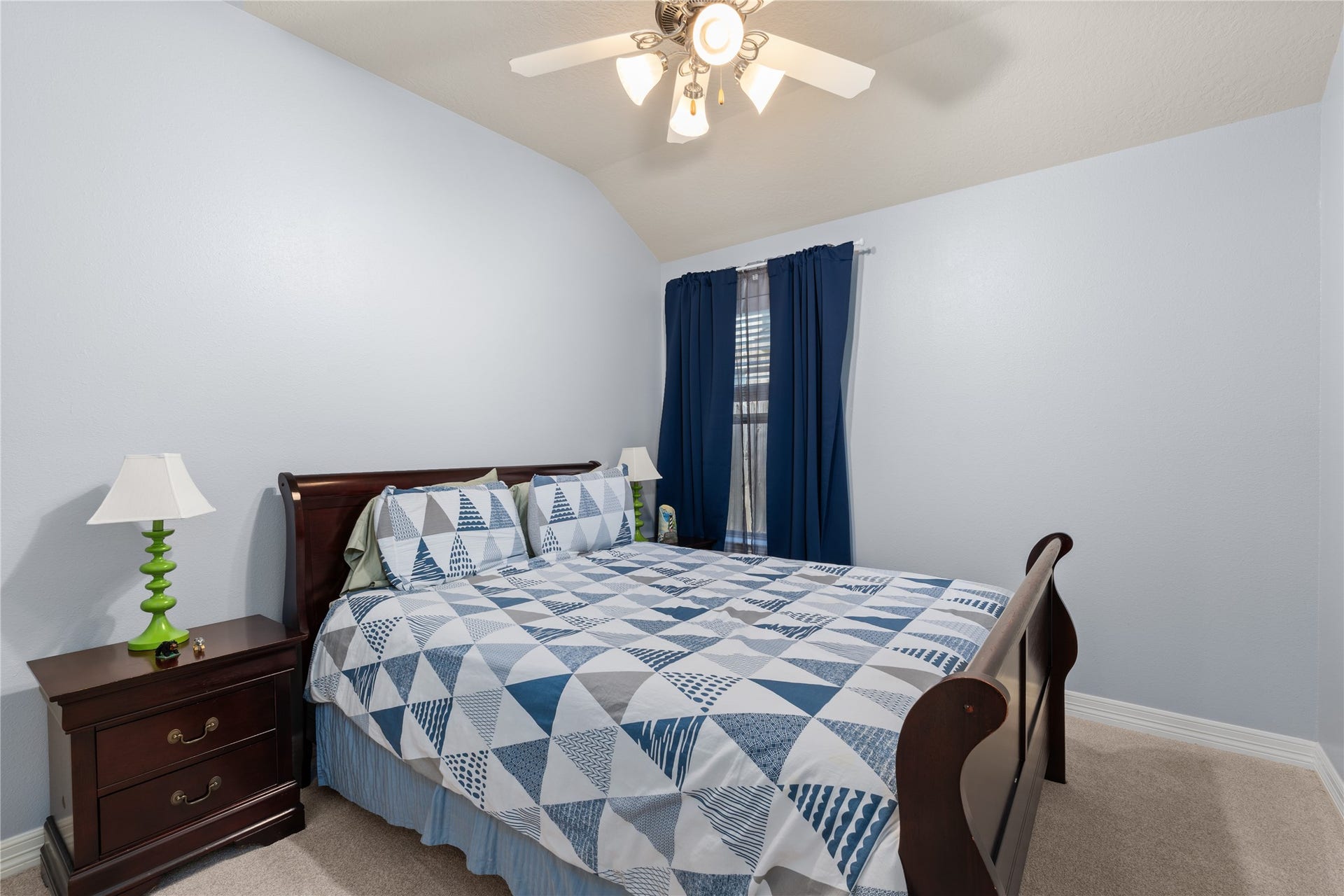 20184 Bitter Root Drive, Porter, TX 77365 Cozy bedroom featuring a comfortable bed with a geometric quilt, complemented by rich wooden furniture and soft lighting.