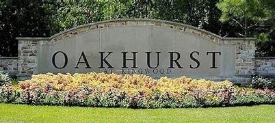 20184 Bitter Root Drive, Porter, TX 77365 Welcome to Oakhurst at Kingwood, a beautifully landscaped community entrance surrounded by lush greenery and vibrant flowers.