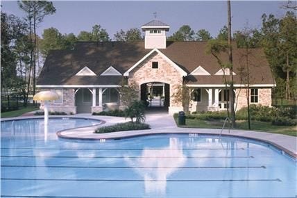 20184 Bitter Root Drive, Porter, TX 77365 Stunning community pool with a charming clubhouse backdrop, surrounded by lush greenery for a perfect blend of relaxation and leisure.