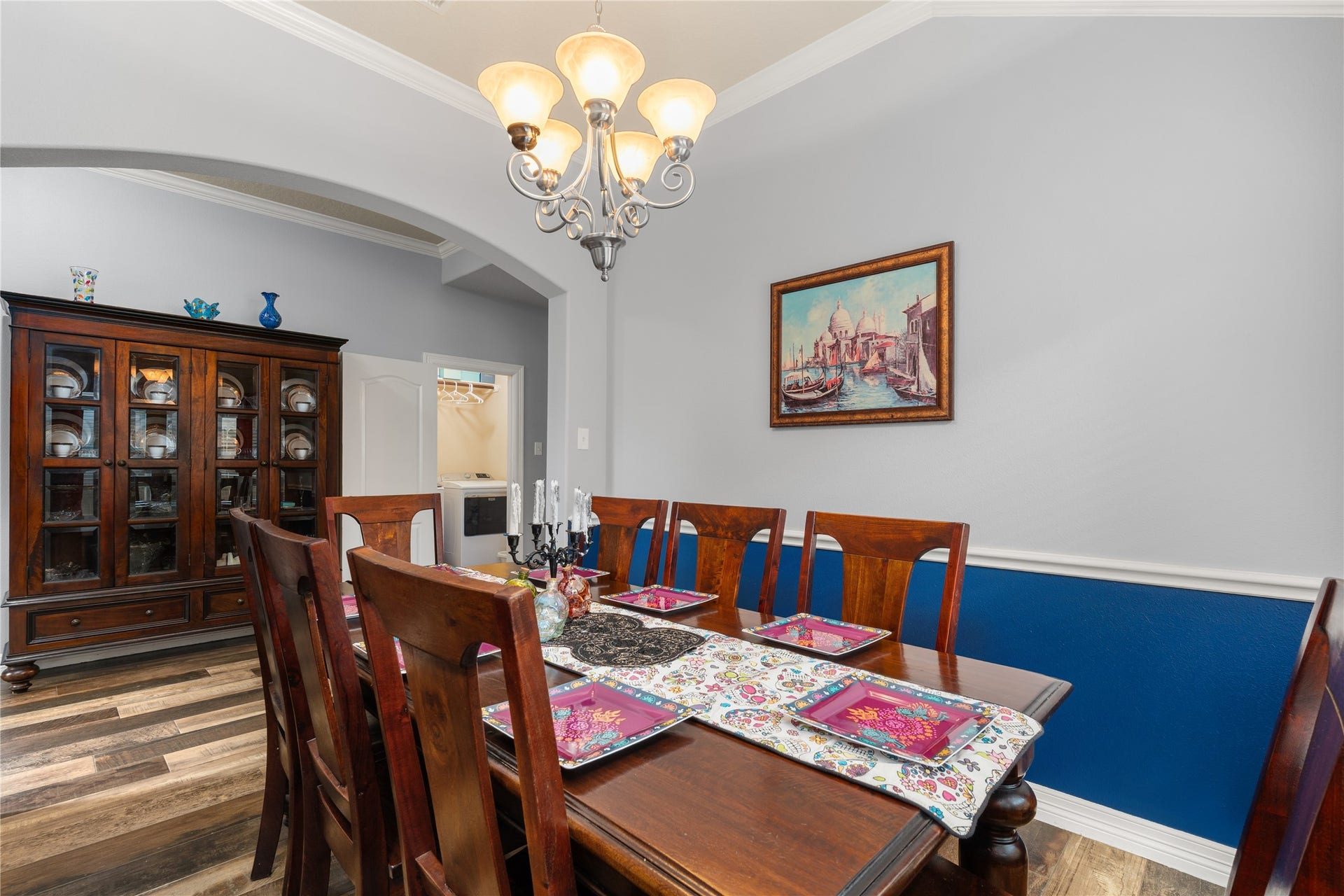20184 Bitter Root Drive, Porter, TX 77365 Elegant dining room featuring rich wood furniture, a stylish chandelier, and a vibrant accent wall, perfect for hosting gatherings.