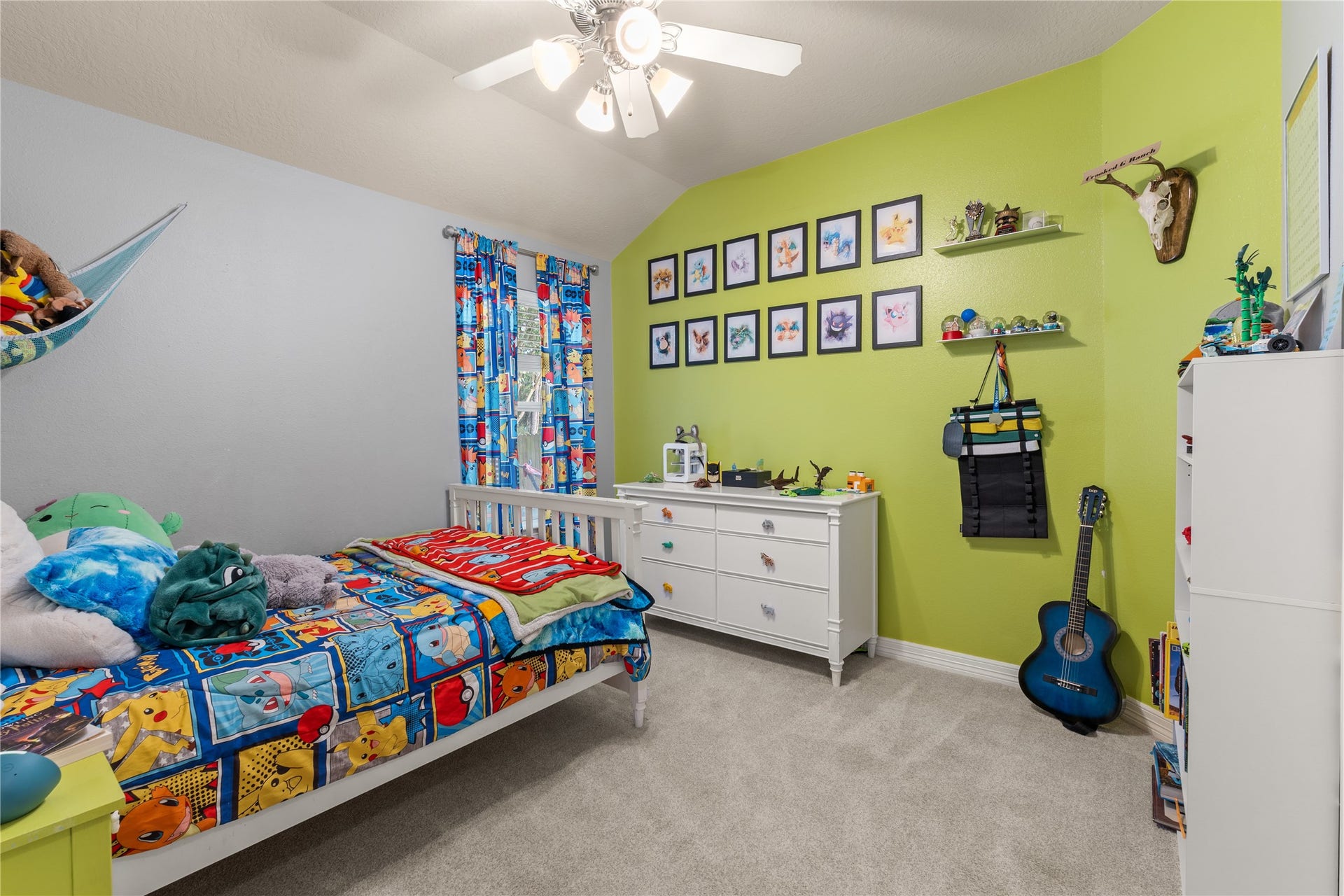 20184 Bitter Root Drive, Porter, TX 77365 Bright and cheerful bedroom with playful decor, featuring colorful curtains, themed bedding, and a vibrant green accent wall adorned with framed art.