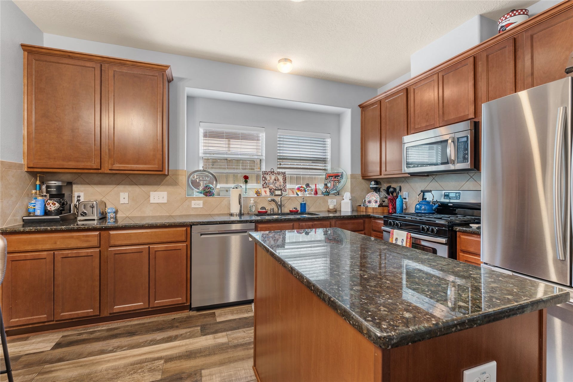 20184 Bitter Root Drive, Porter, TX 77365 A modern kitchen featuring sleek stainless steel appliances, rich wood cabinetry, and a spacious granite-topped island with ample counter space for meal prep and entertaining.