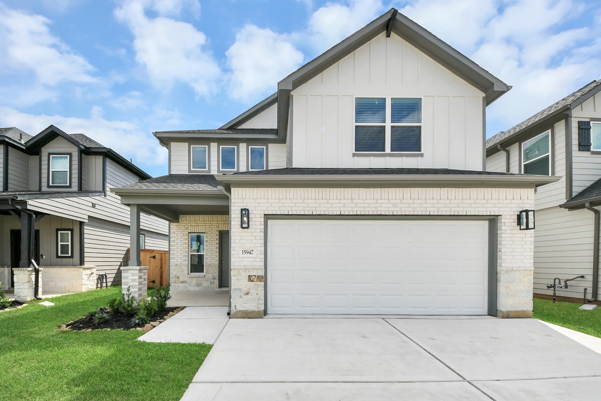 15947 Sycamore Maple Lane, Cypress, TX 77429 This home boasts lush green grass and meticulous landscaping. Its premium elevation showcases an exquisite blend of brick and stone features, complemented by modern coach lighting