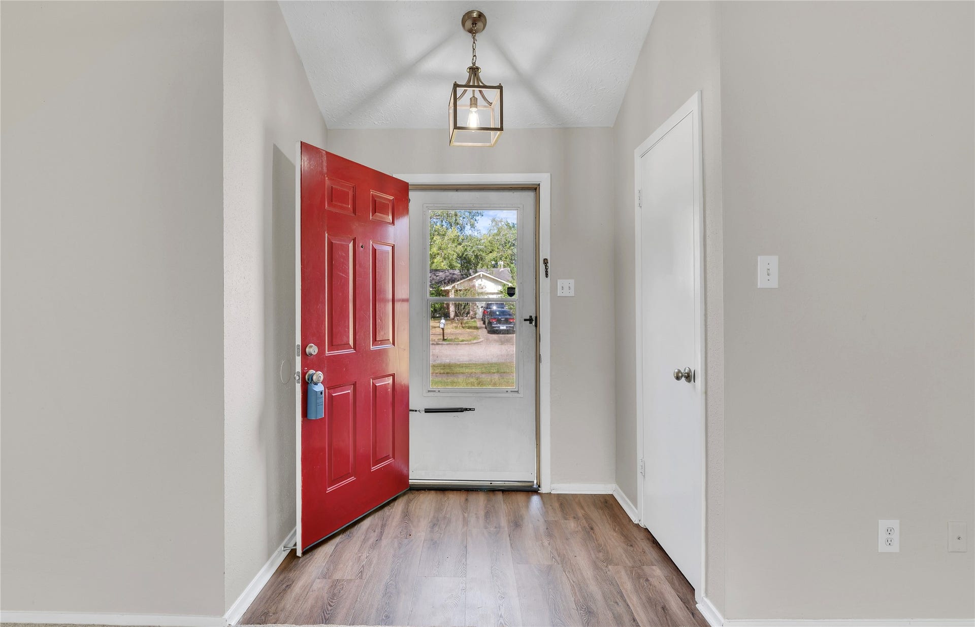 2515 Knoxville Drive, League City, TX 77573 Entryway with storm door and hanging light fixture. Vinyl plank flooring.