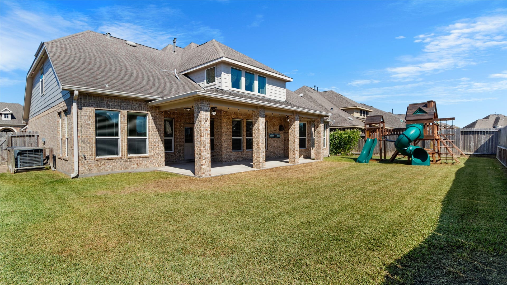 12106 Obsidian Lane, Mont Belvieu, TX 77535 A great view of the large backyard and the fully covered back patio. The playground has been removed since taking the photos.