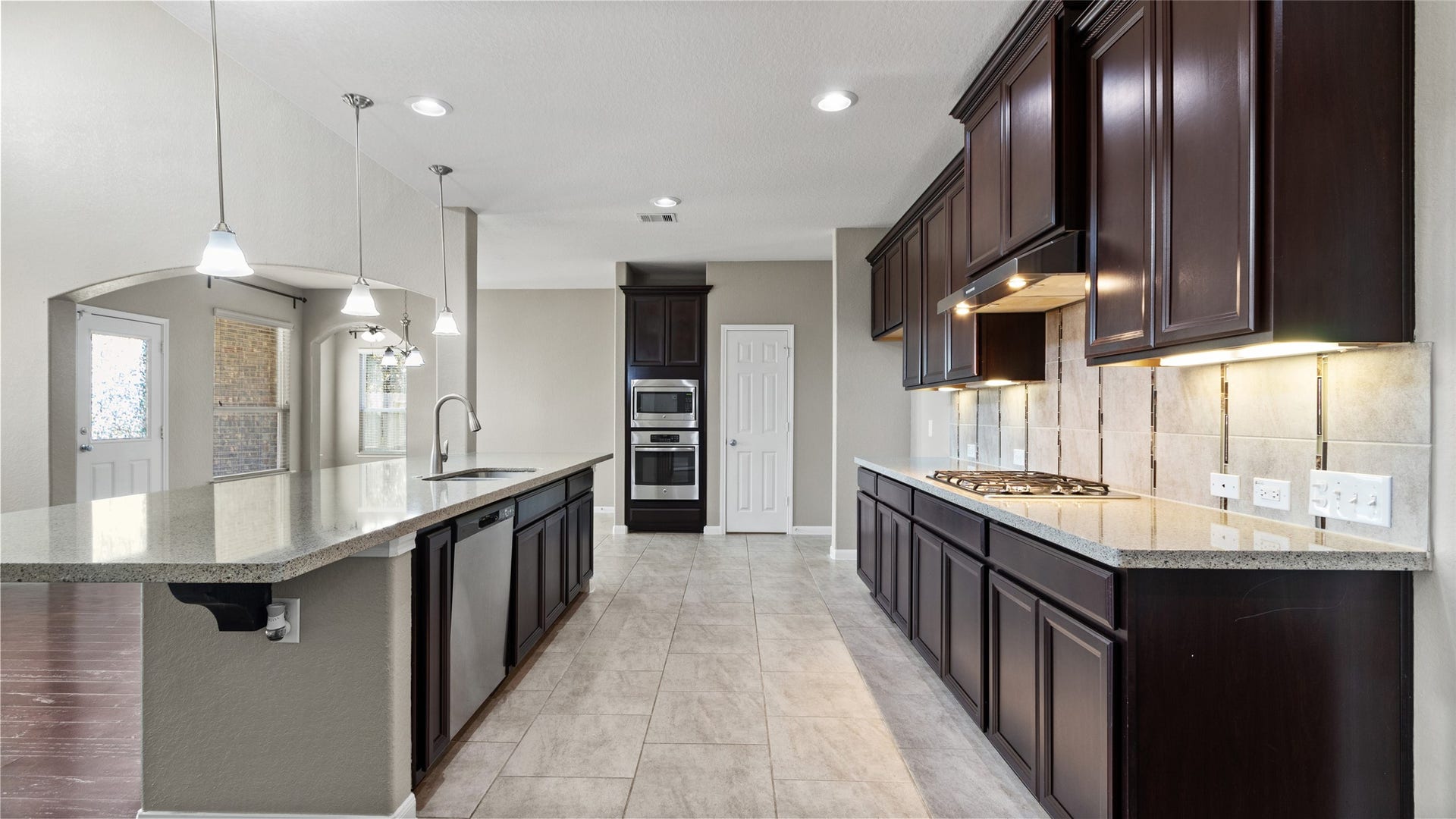 12106 Obsidian Lane, Mont Belvieu, TX 77535 This spacious and inviting kitchen features abundant storage, under-cabinet lighting, a gas cooktop, and a massive island equipped with two deep stainless steel sinks. Open to both the living and breakfast areas, this kitchen is the perfect space for daily gathering and entertaining.