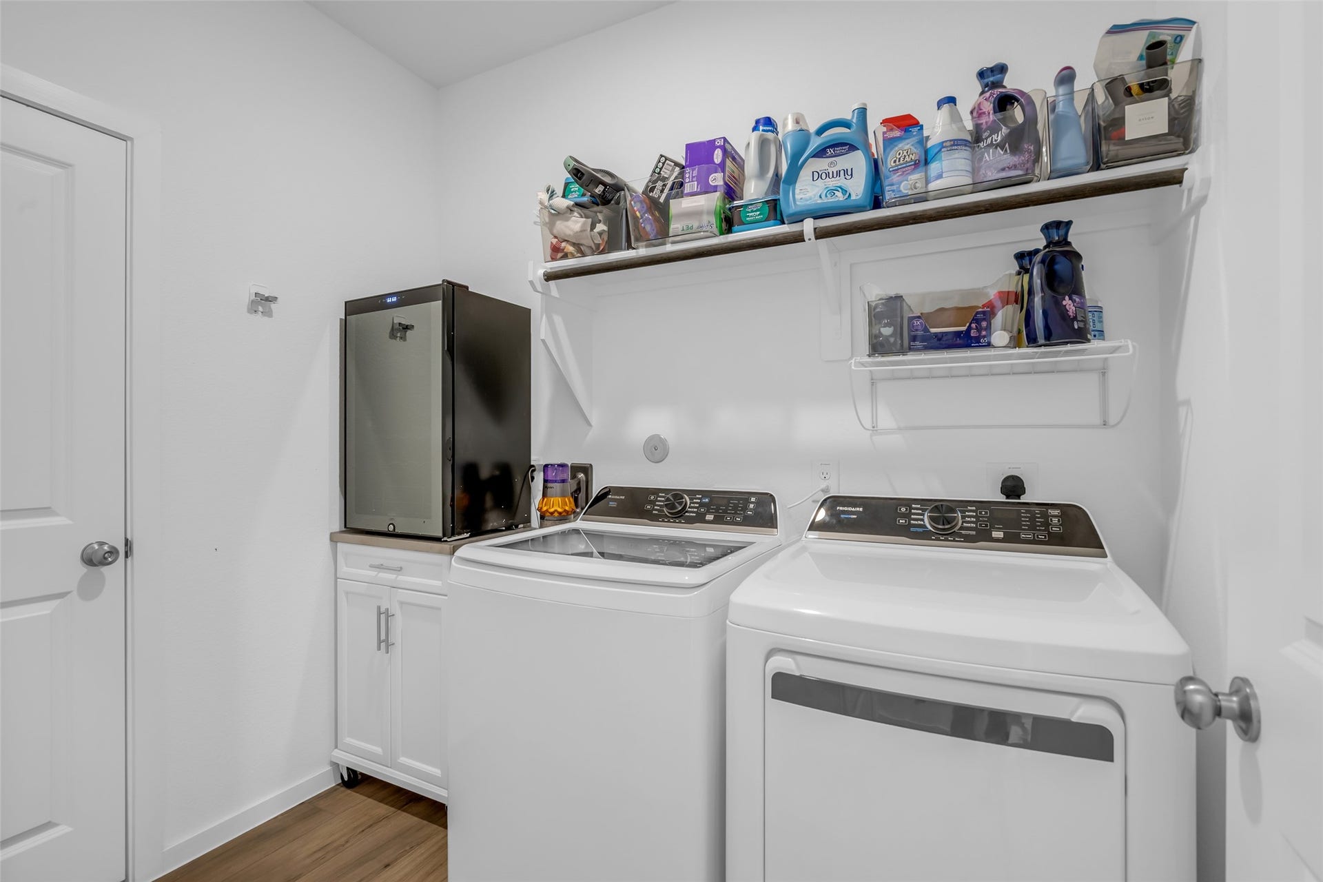 13213 Harbor Point Drive, Texas City, TX 77539 Efficient laundry room featuring modern washer and dryer, ample shelving for storage, and a convenient utility cabinet.