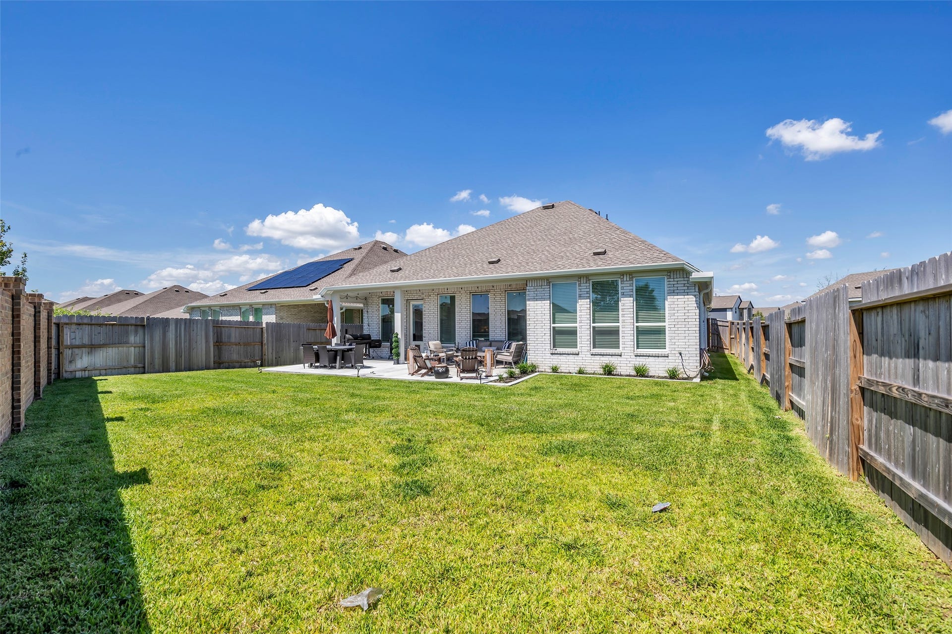 13213 Harbor Point Drive, Texas City, TX 77539 Expansive backyard with lush green lawn, perfect for outdoor gatherings, featuring a cozy patio area ideal for dining and relaxation.