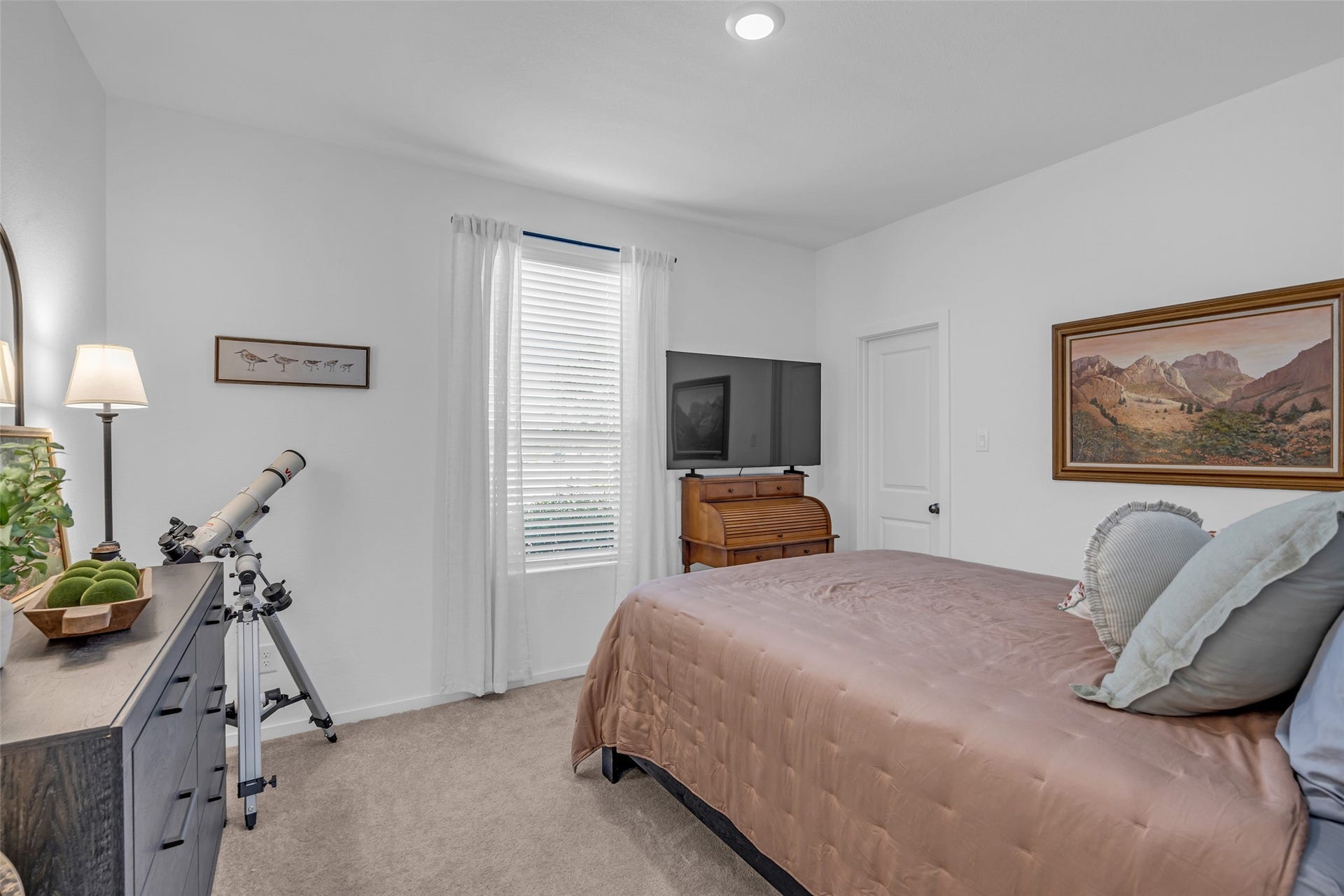 13213 Harbor Point Drive, Texas City, TX 77539 Cozy bedroom with natural light, featuring a comfortable bed, a telescope for stargazing, and tasteful decor including framed artwork.