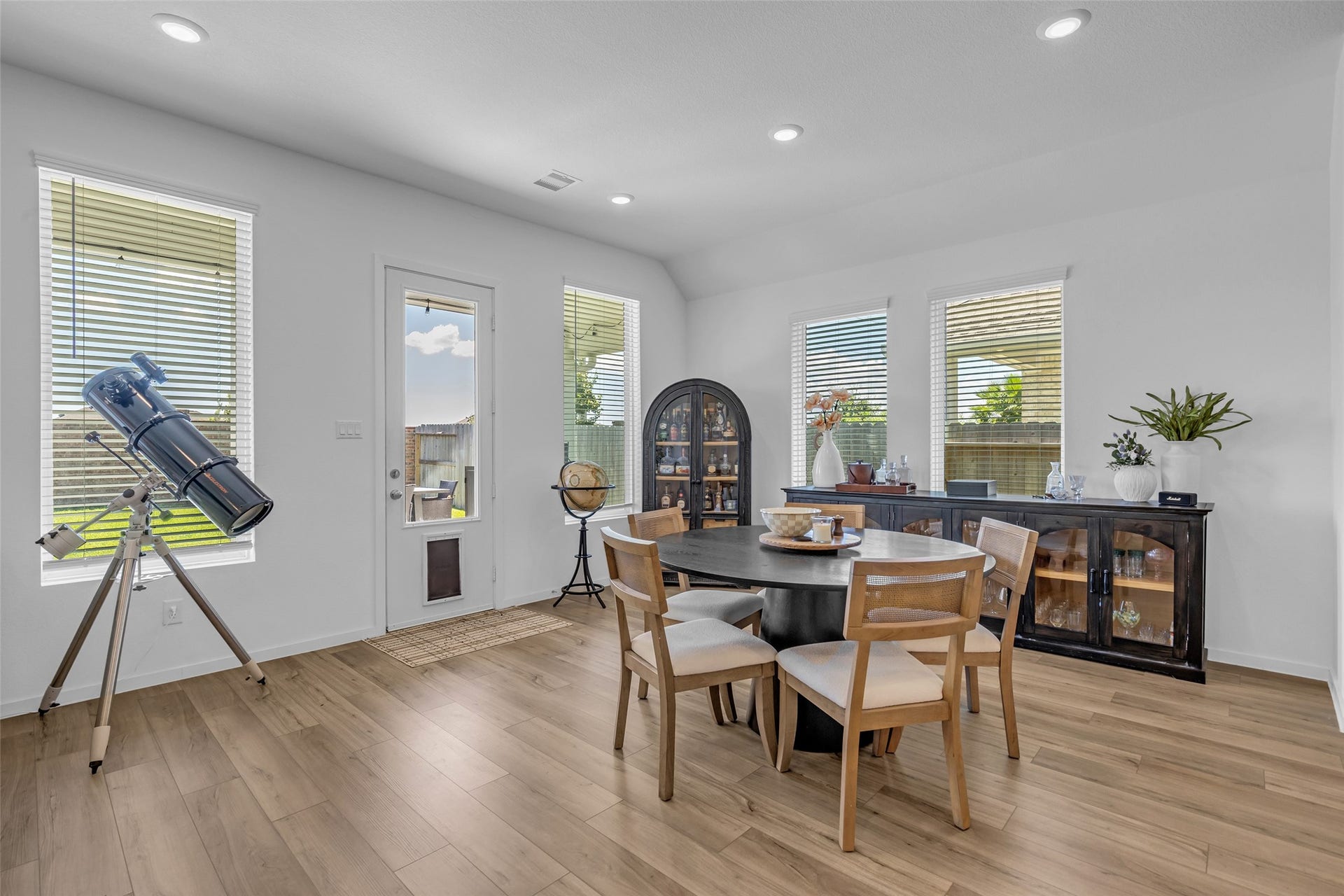 13213 Harbor Point Drive, Texas City, TX 77539 Bright and inviting dining area with large windows, sleek wood flooring, and modern furnishings, perfect for family gatherings.